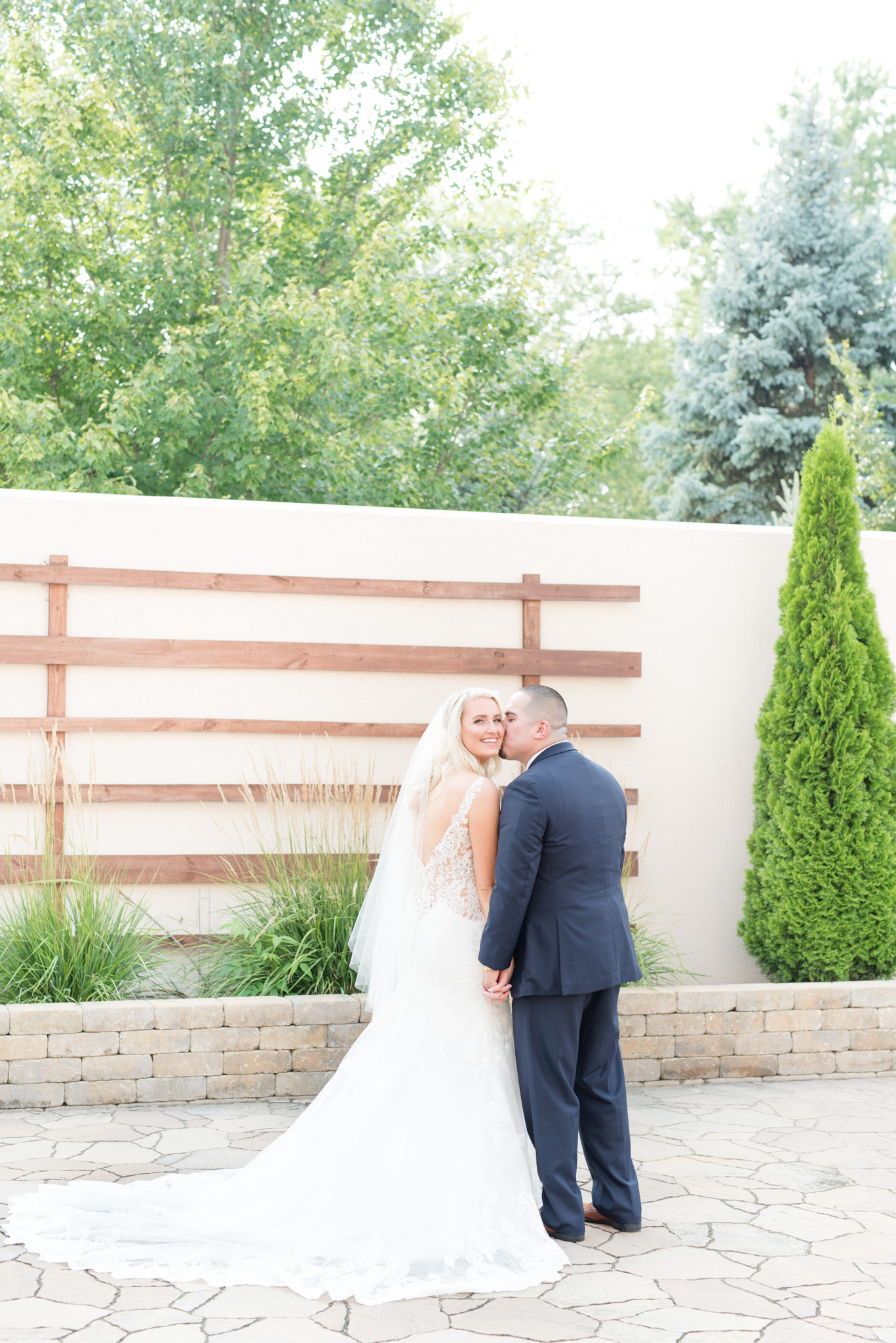 Groom kisses brides cheek.