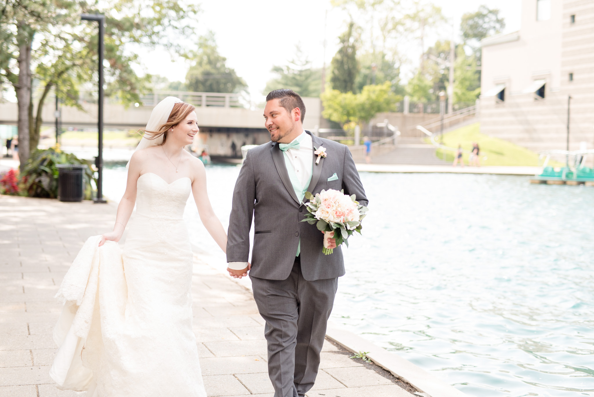Bride and groom walk down Indianapolis canal.