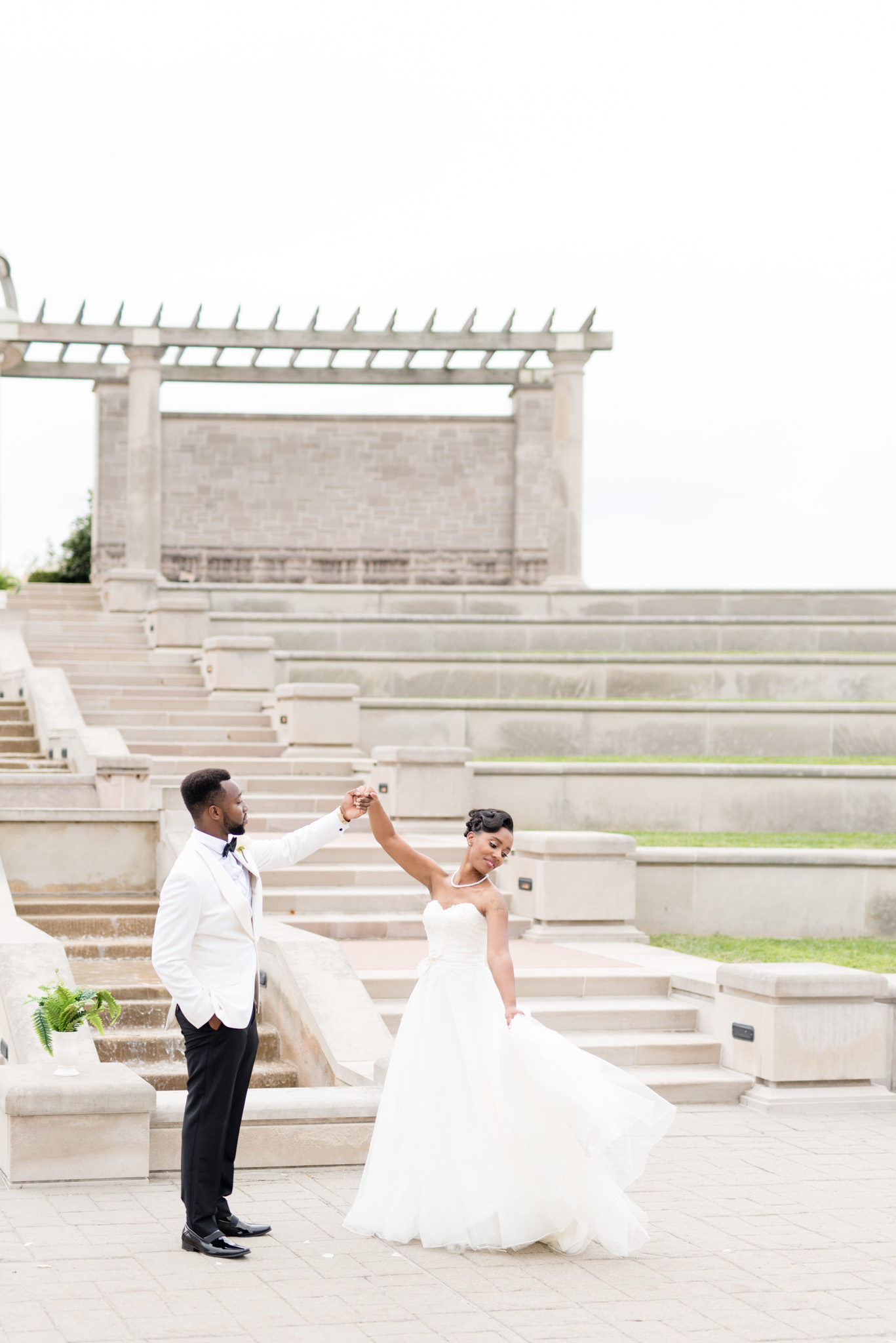 Groom twirls bride at ceremony site.