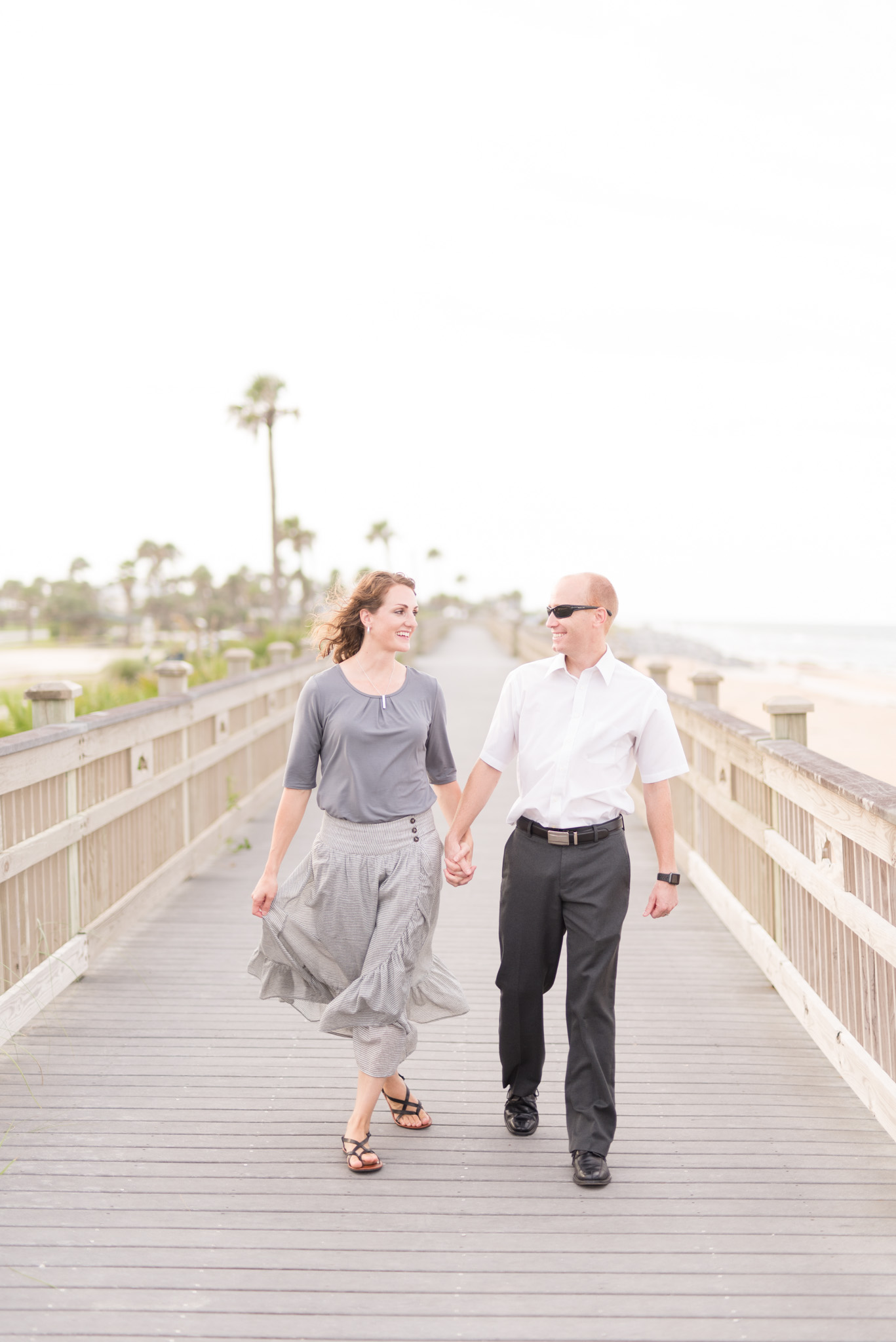 Couple walks together down boardwalk.