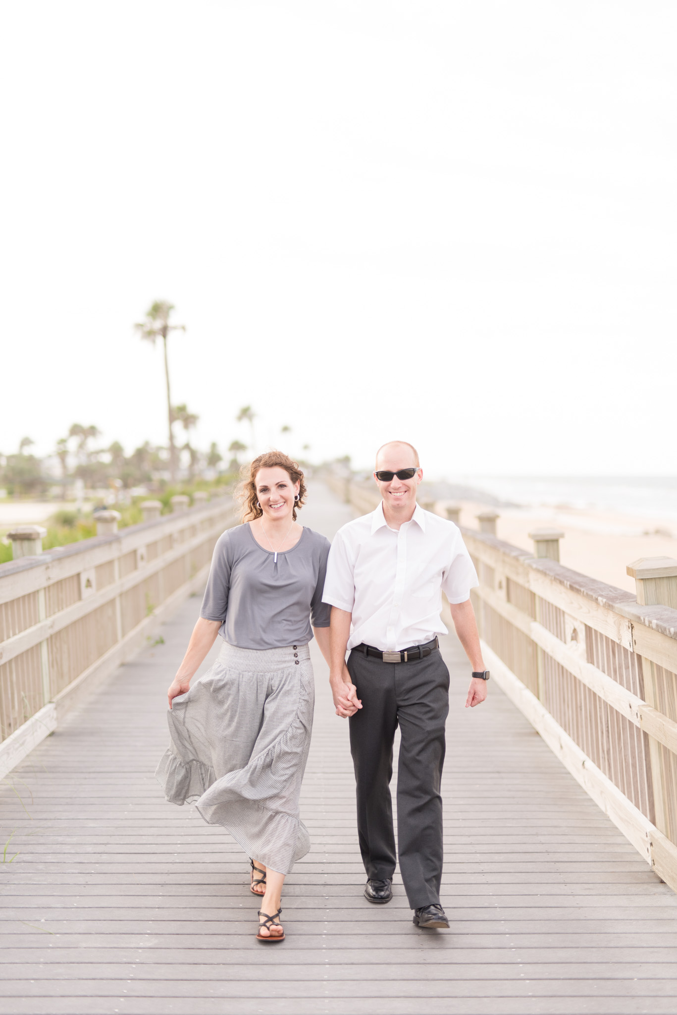 Couple looks at camera and smiles while walking.