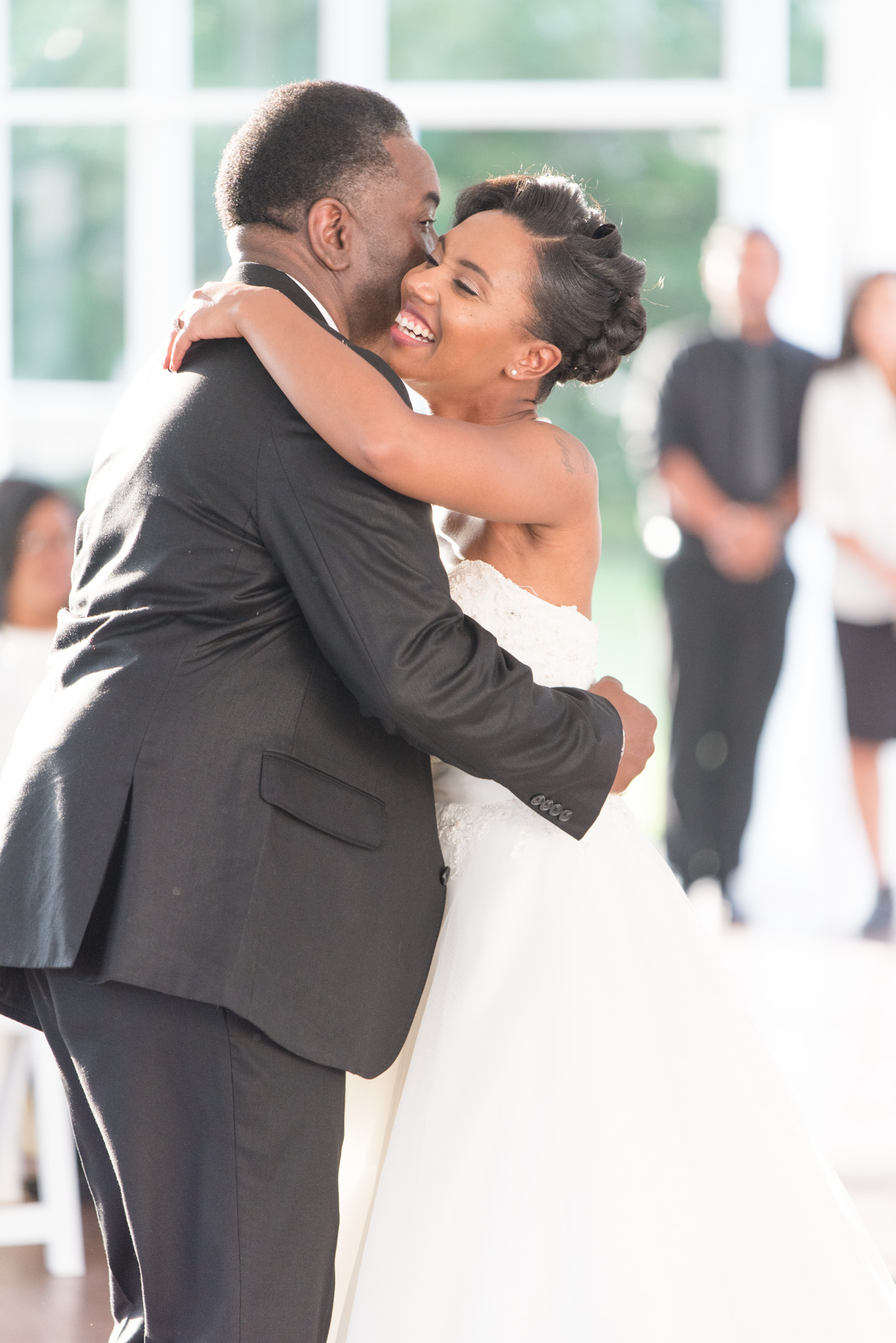 Bride hugs father.