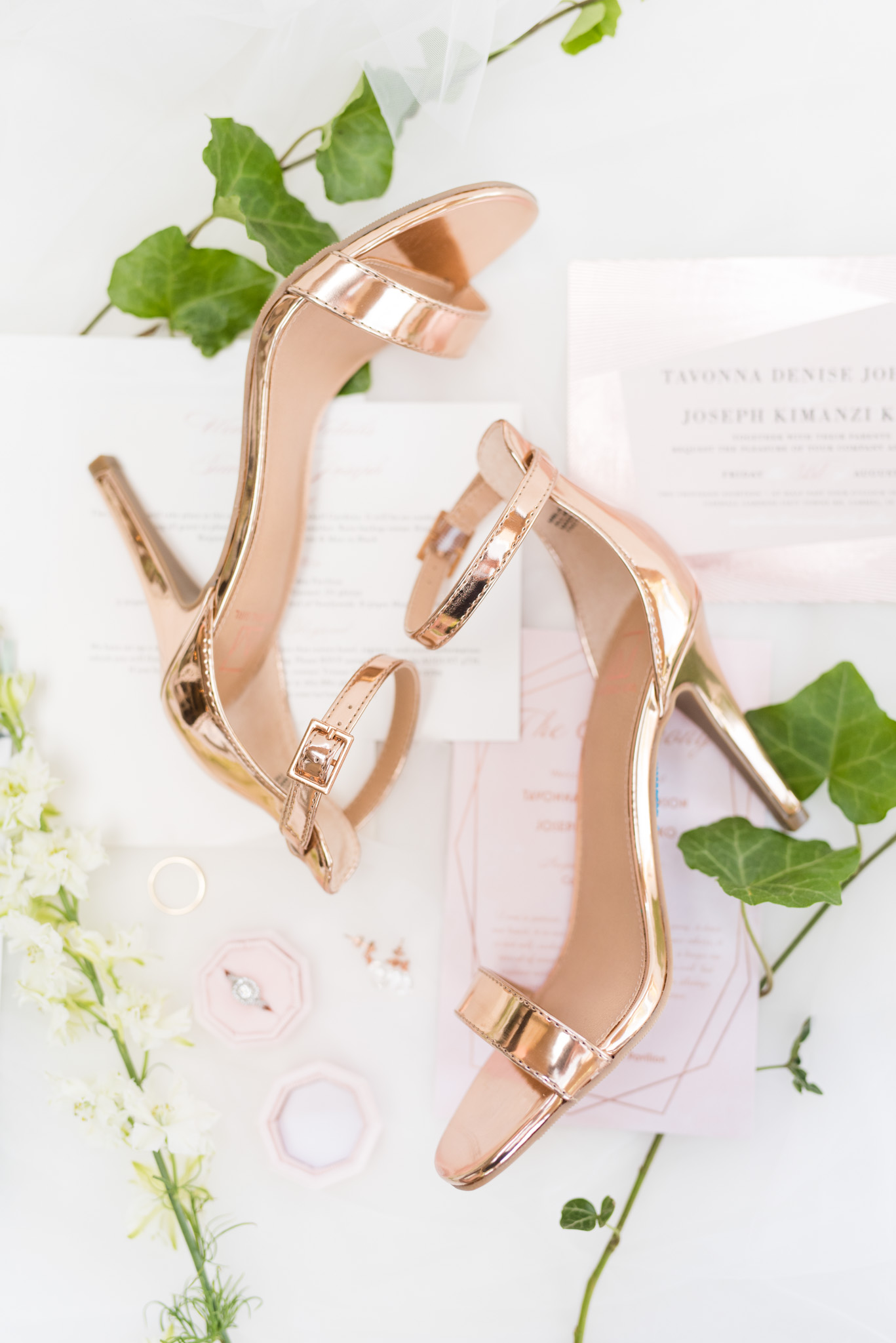 Rose gold heels sit on invitations.