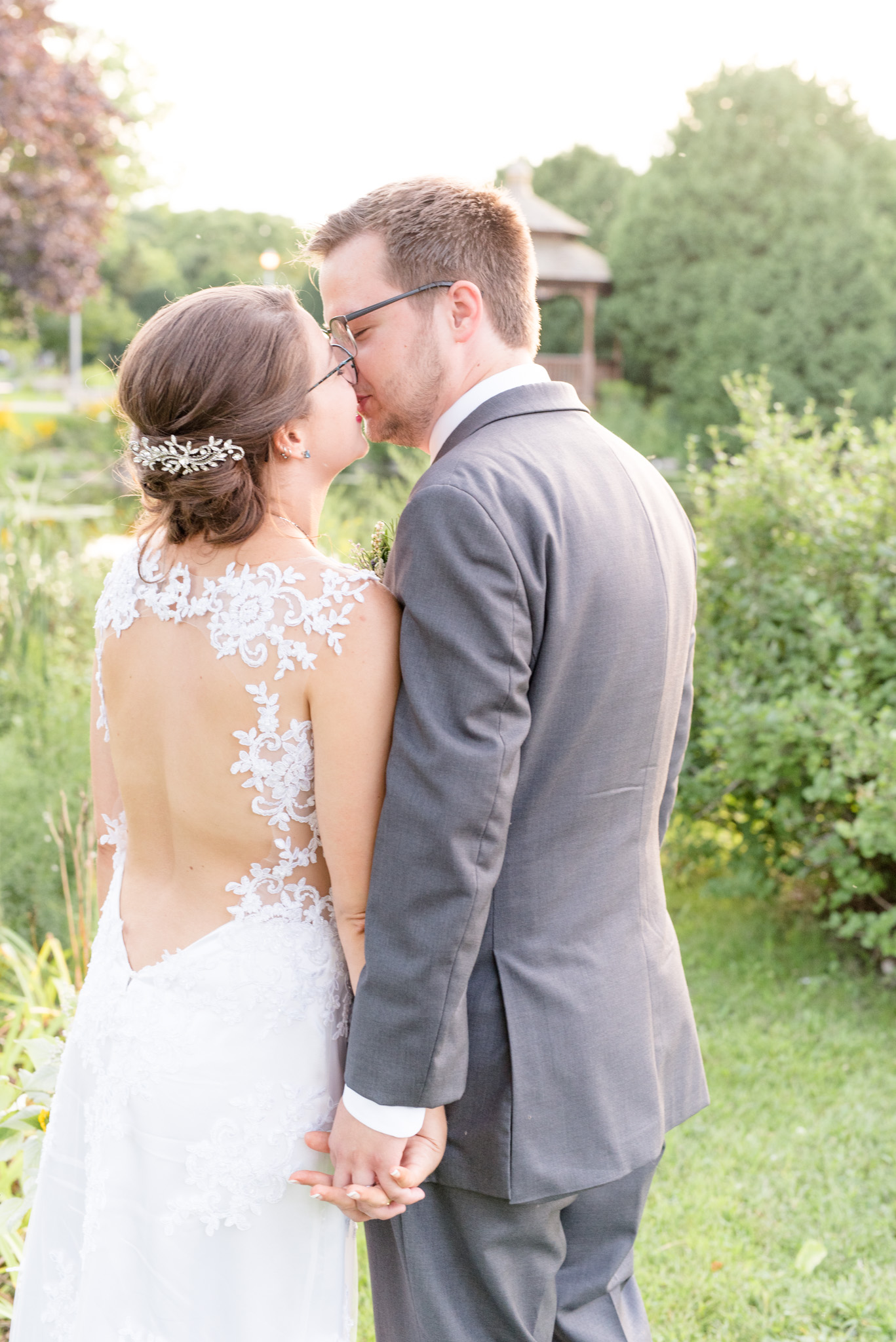 Bride and groom lean in for kiss.