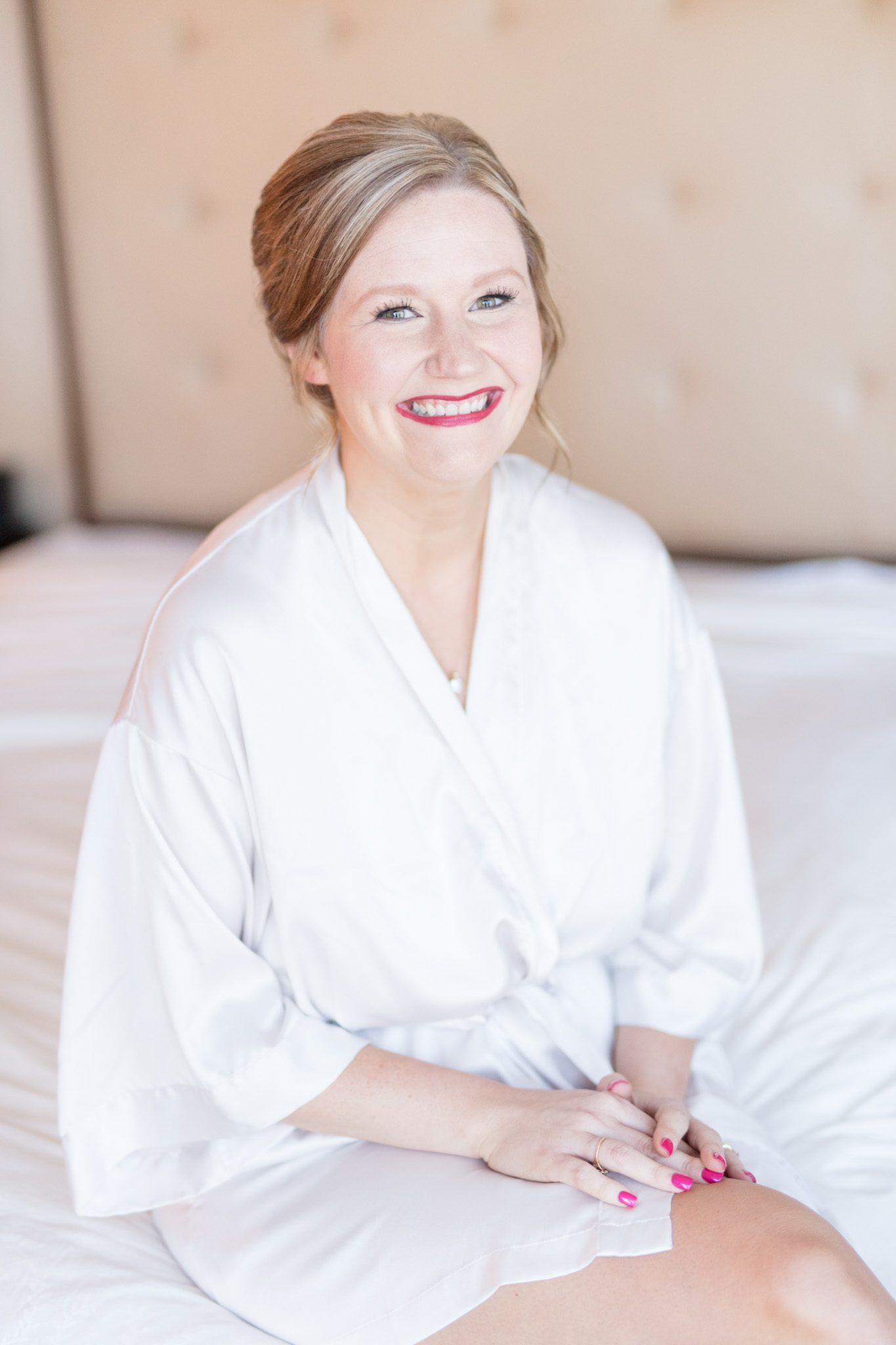 Bride smiles while getting ready.