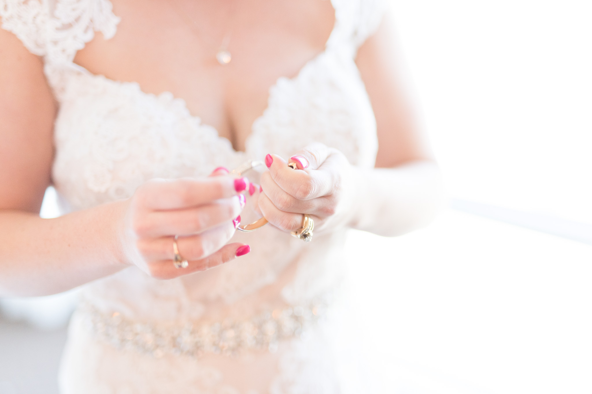 Bride puts on wedding jewelry.