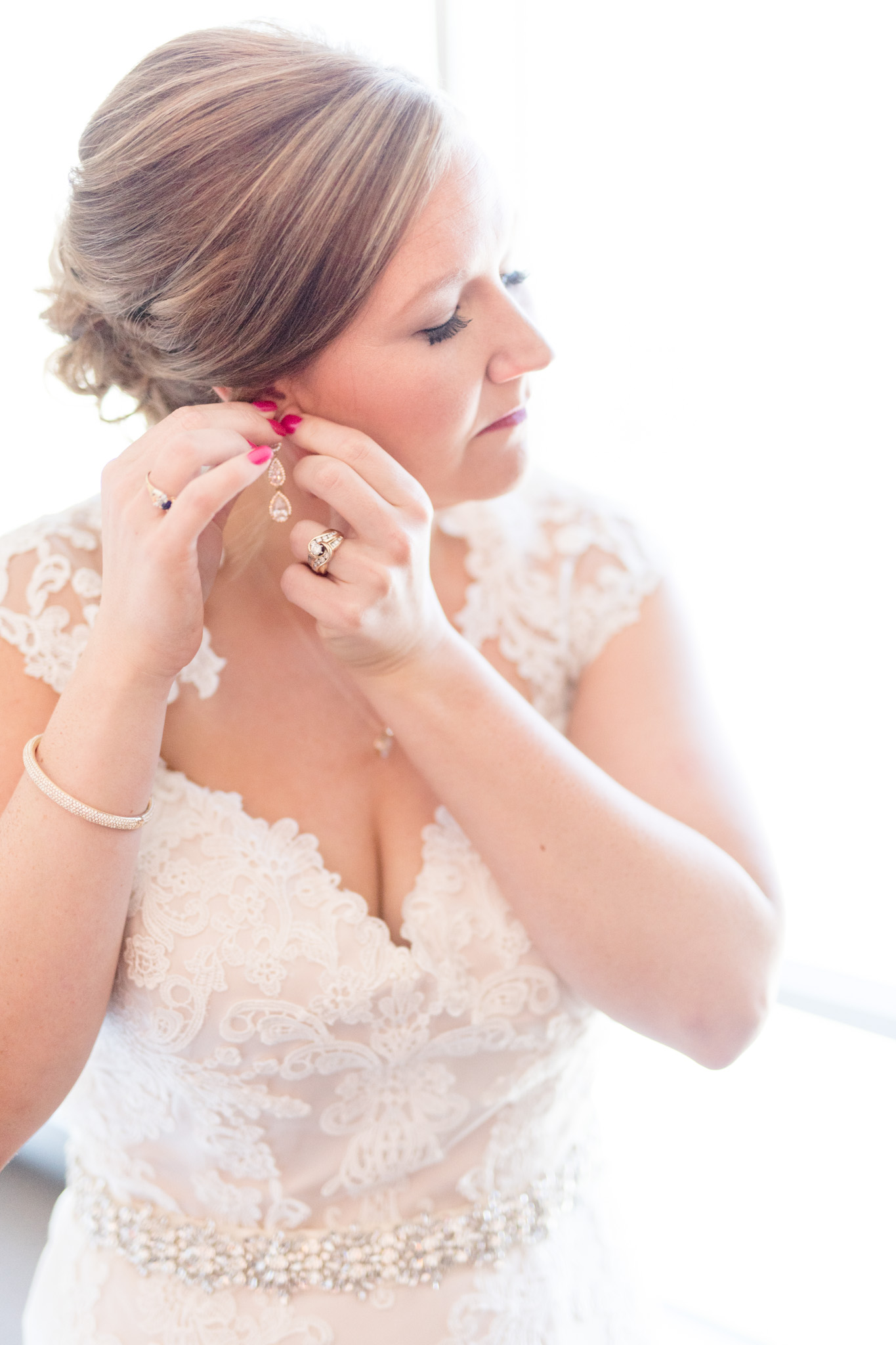 Bride puts on earrings.