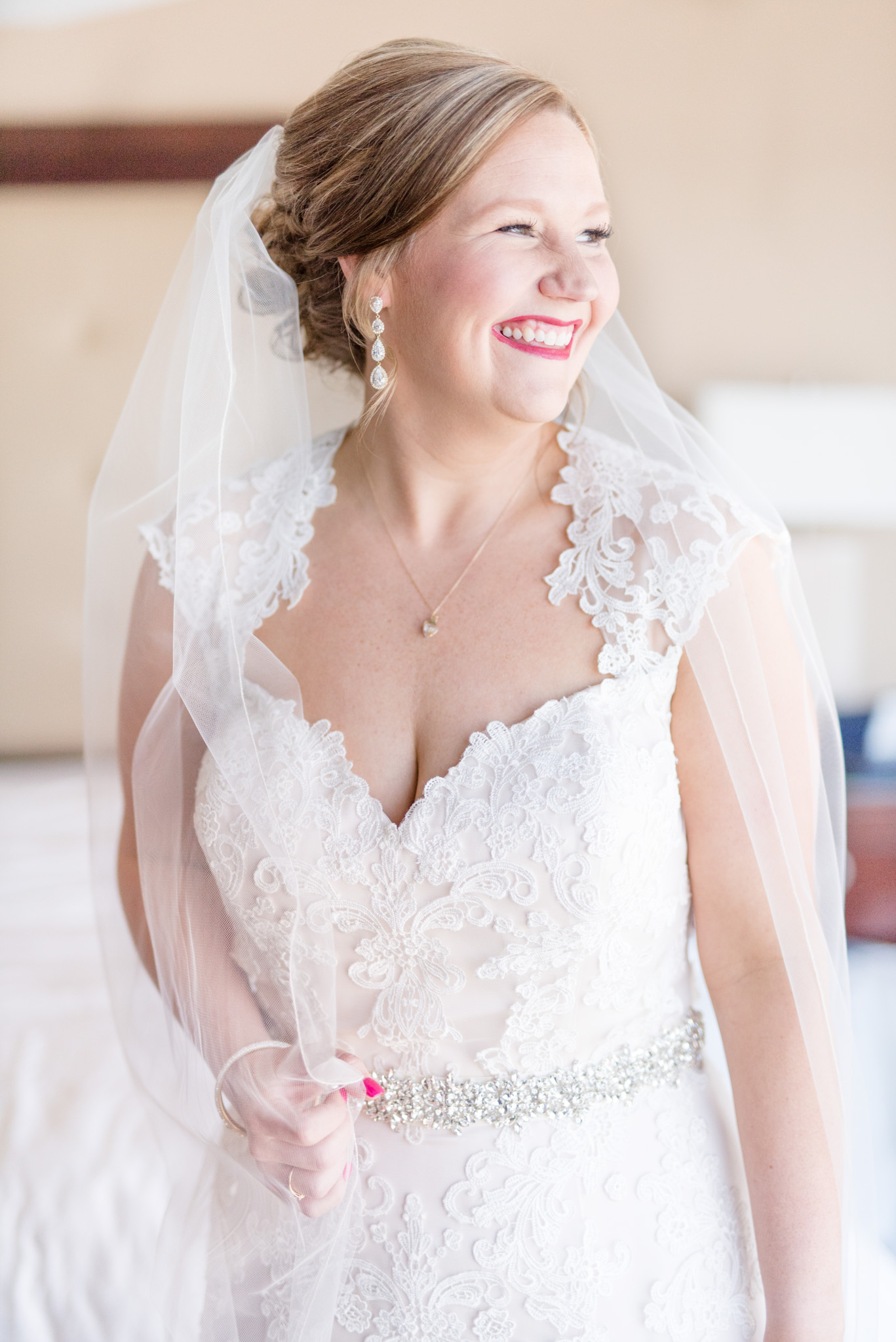 Bride laughs towards window.