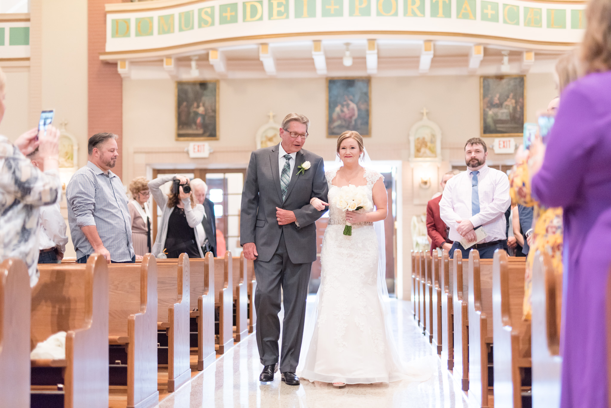 Bride and father walk down aisle.