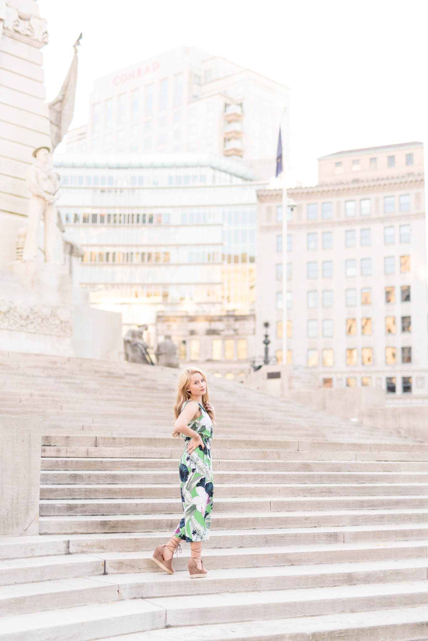 Senior girl looks over shoulder on downtown stairs.