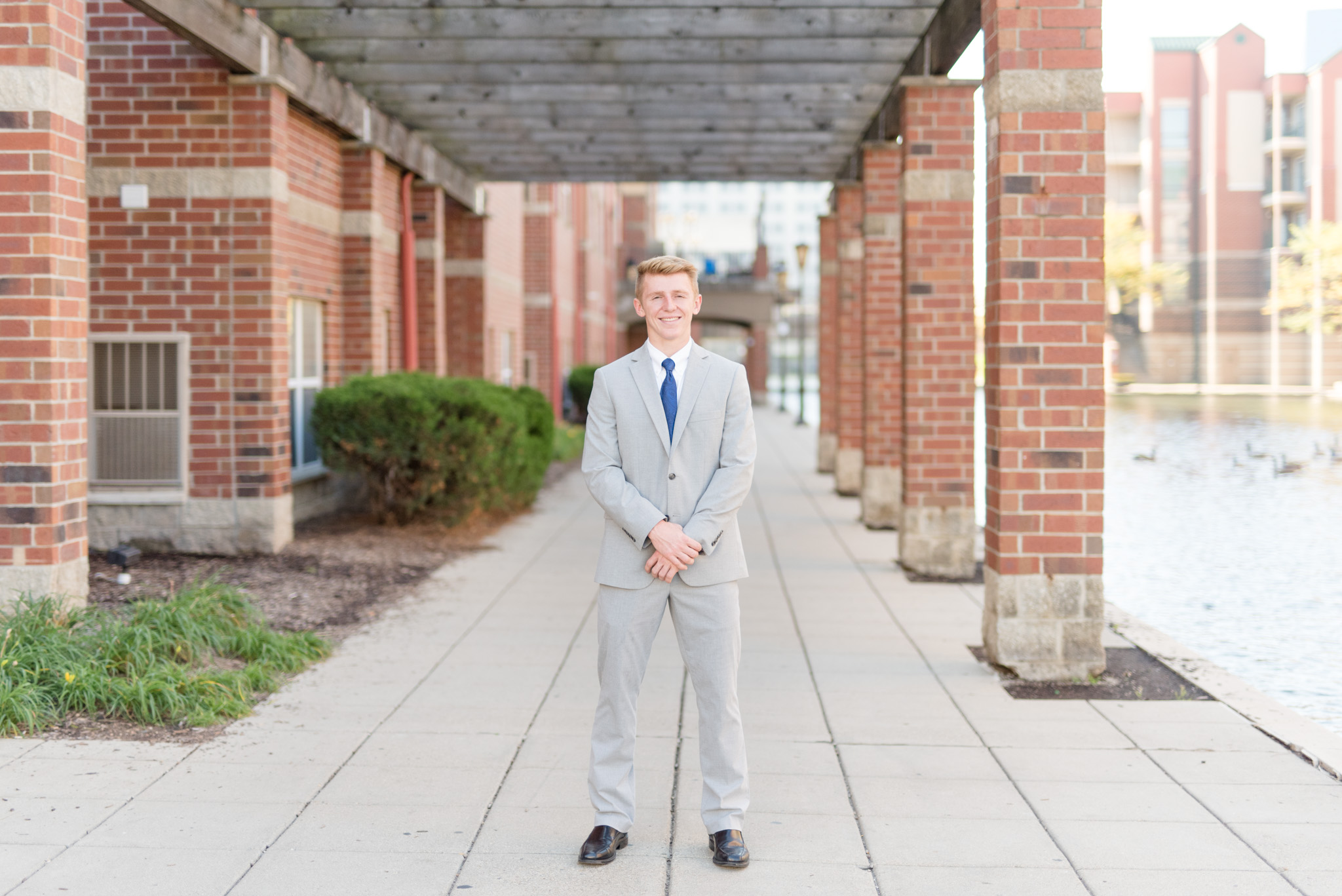 Guy smiles at camera with brick columns.