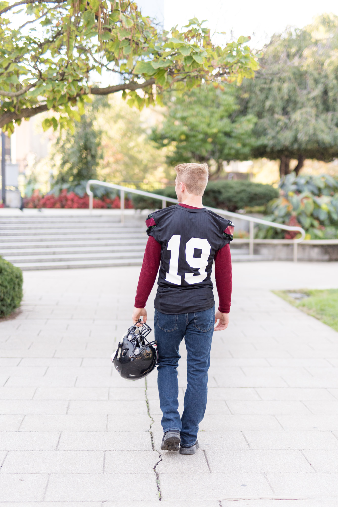 Guy walks away with football helmet.