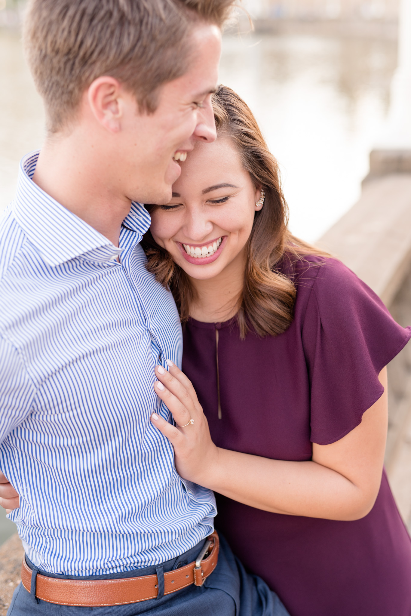 Engaged couple cuddles and laughs.