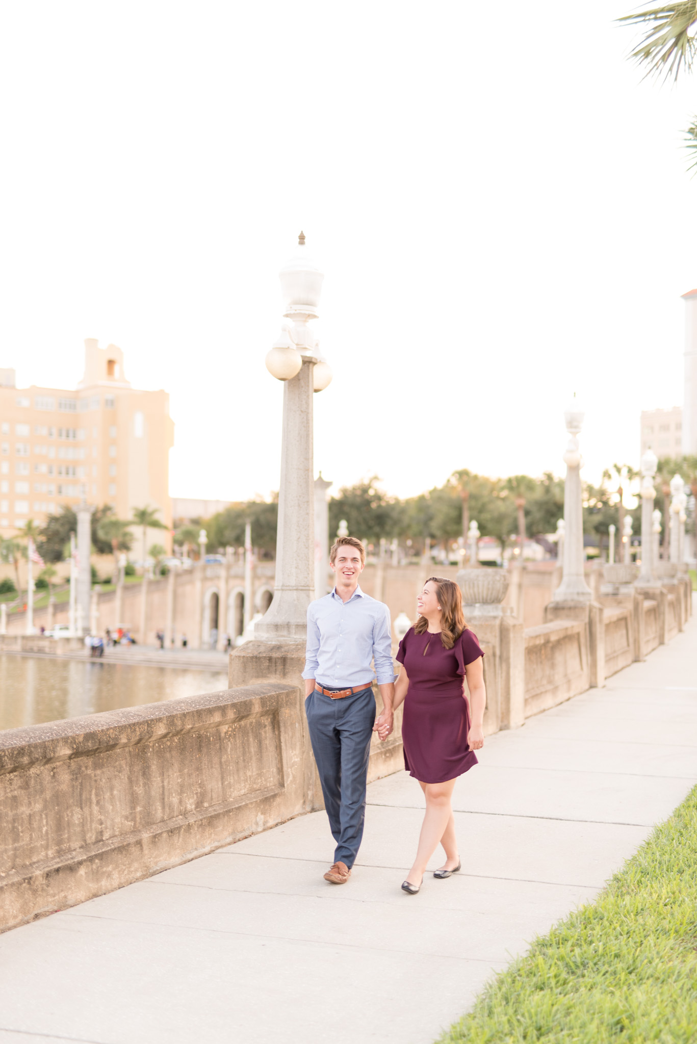 Couple walks along sunset path with view of city.