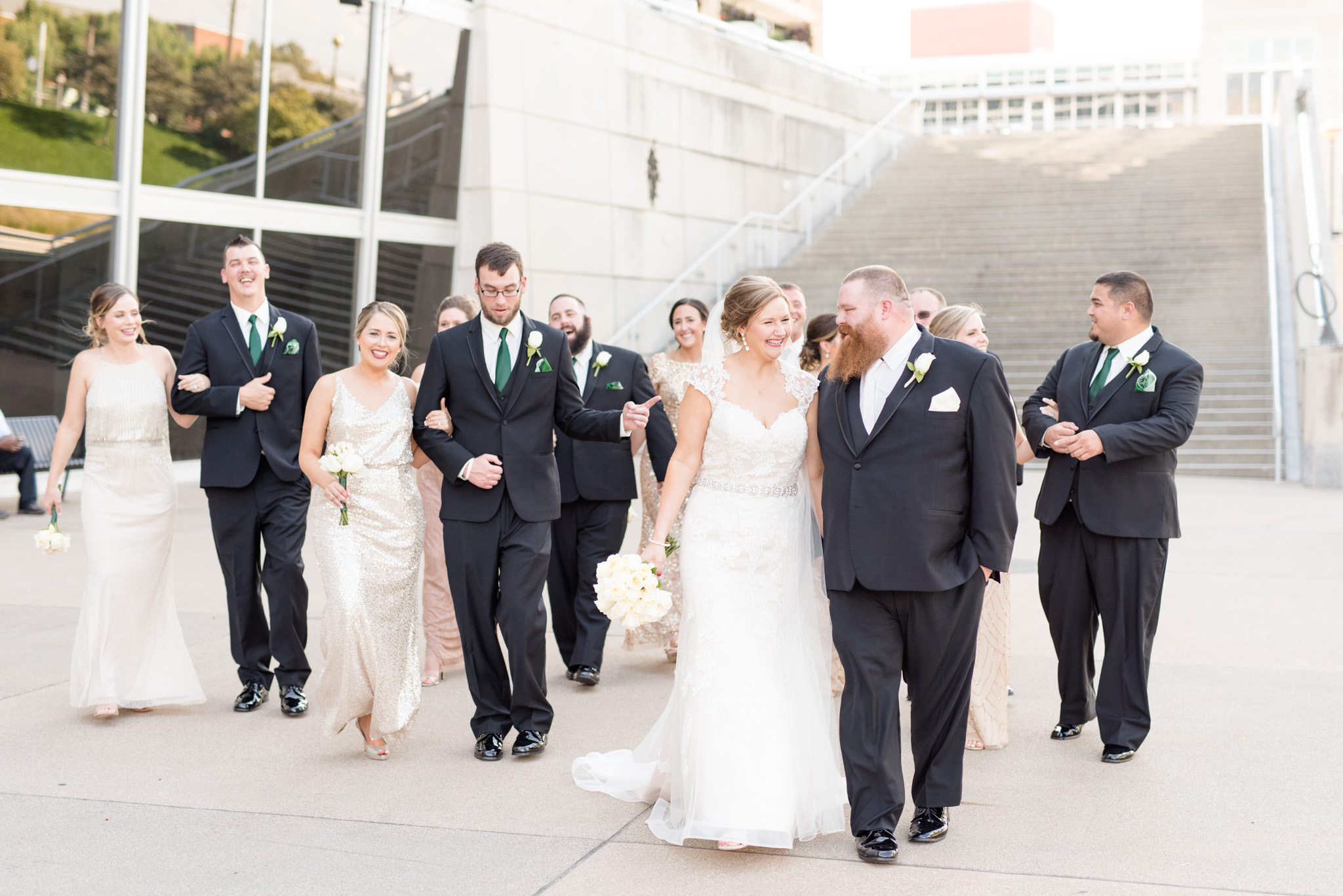 Bride and groom walk with wedding party.