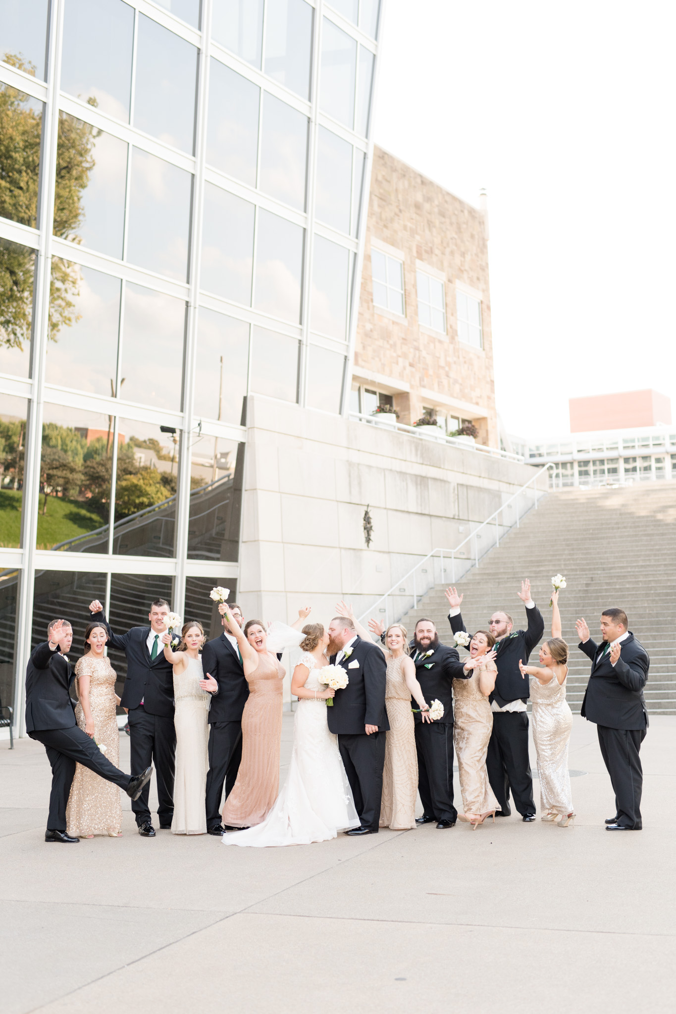 Wedding party cheers as bride and groom kiss!