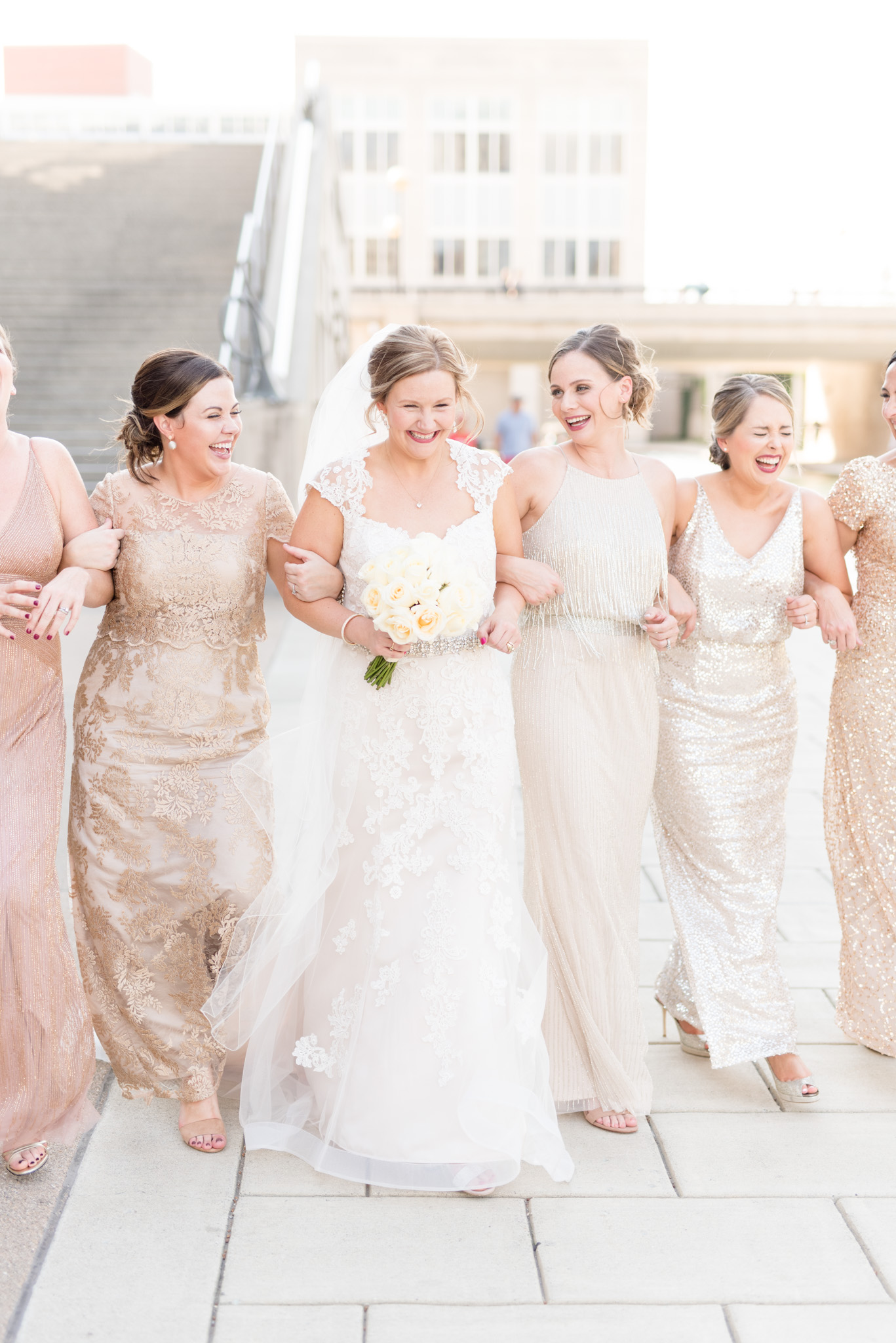 Bride walks downtown with bridesmaids.