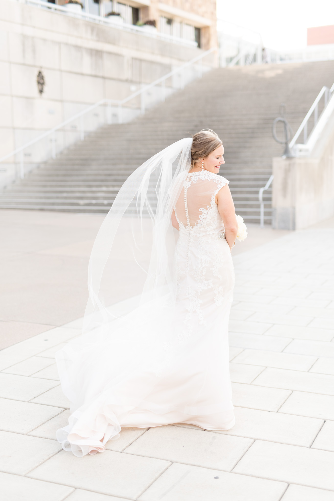 Bride shows off back of dress.