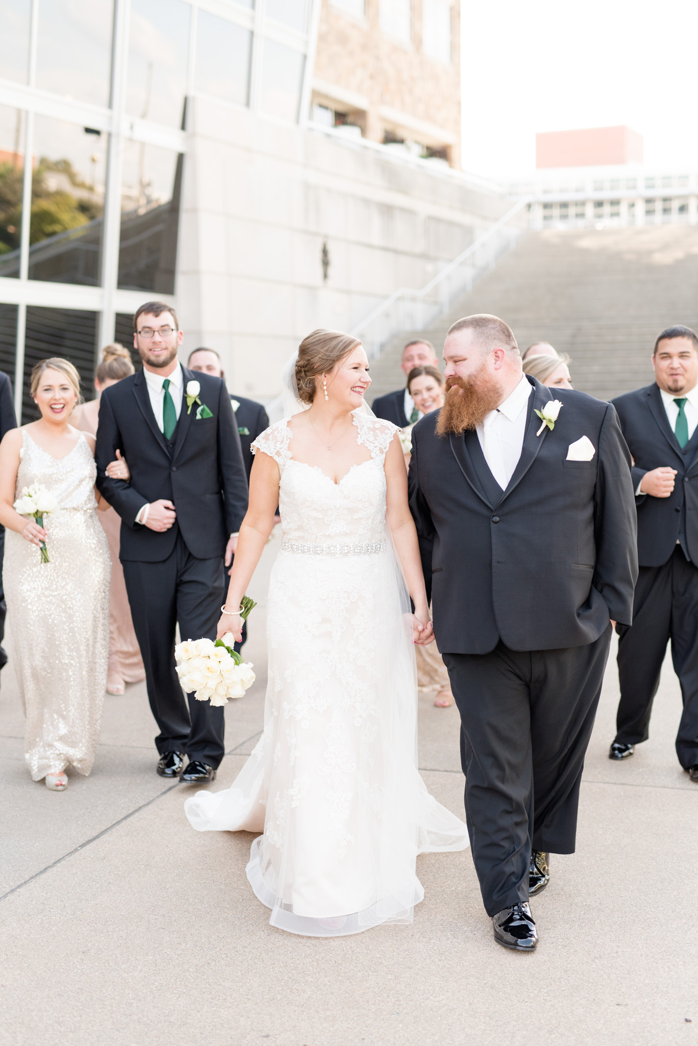 Bride and groom walk with in downtown Indianapolis with wedding party.