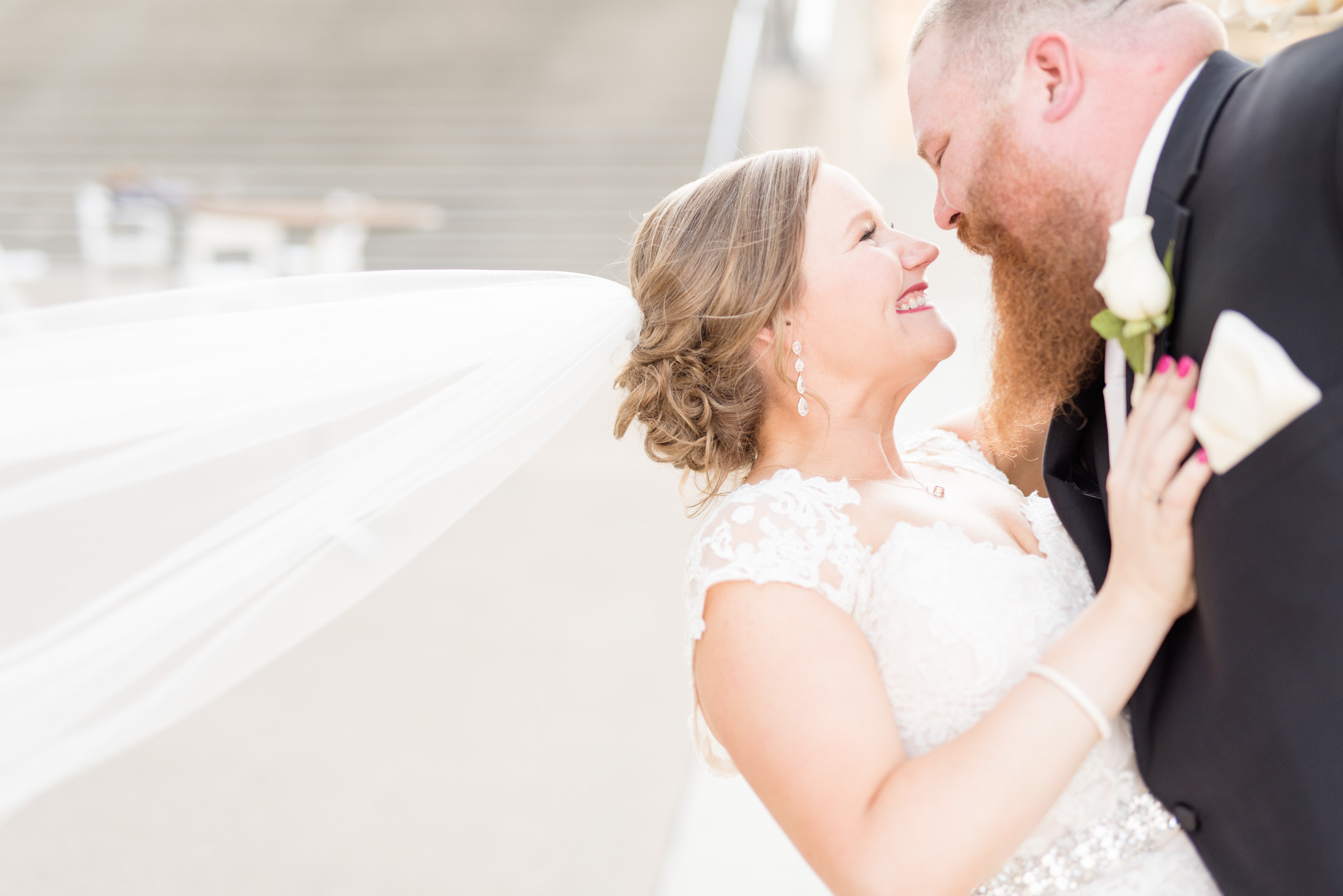 Groom dips bride as they lean in for kiss.