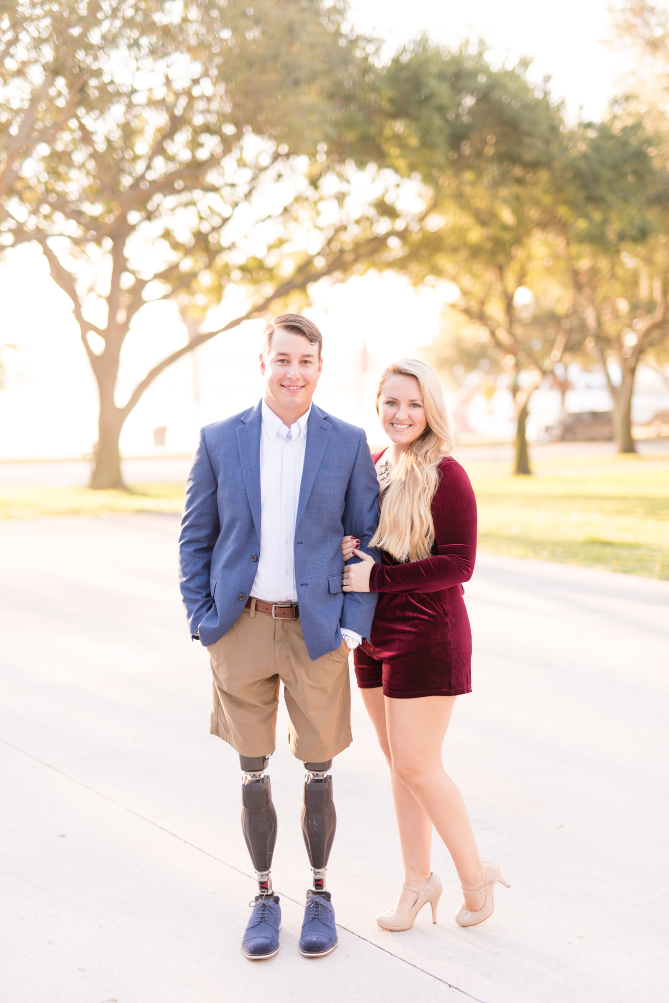 Couple smiles at camera during sunrise.