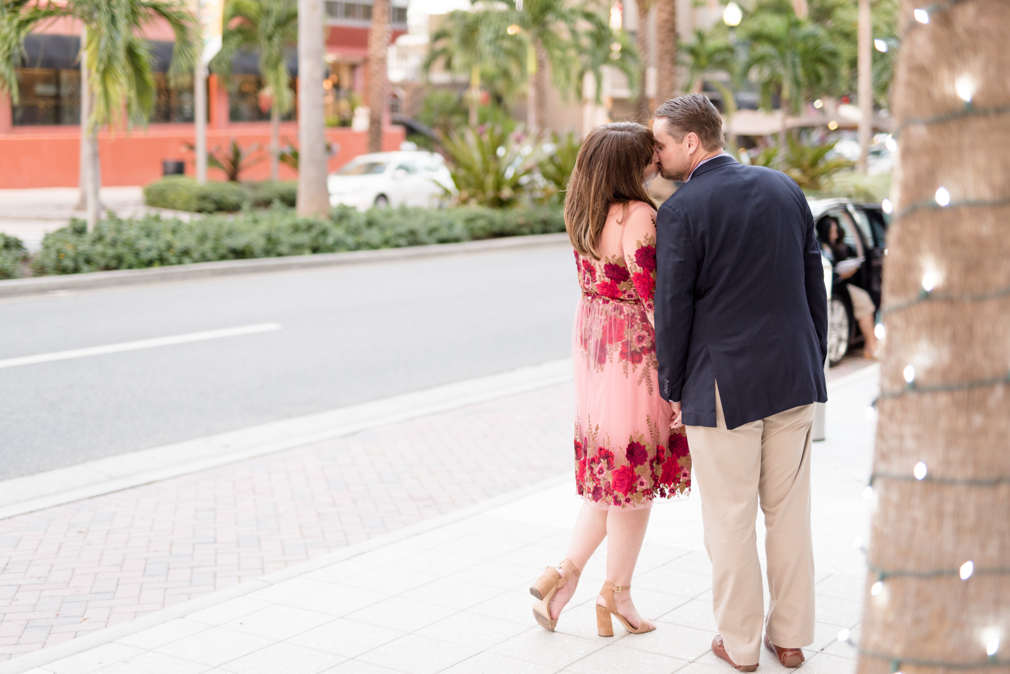 Couple leans in for kiss in urban setting.