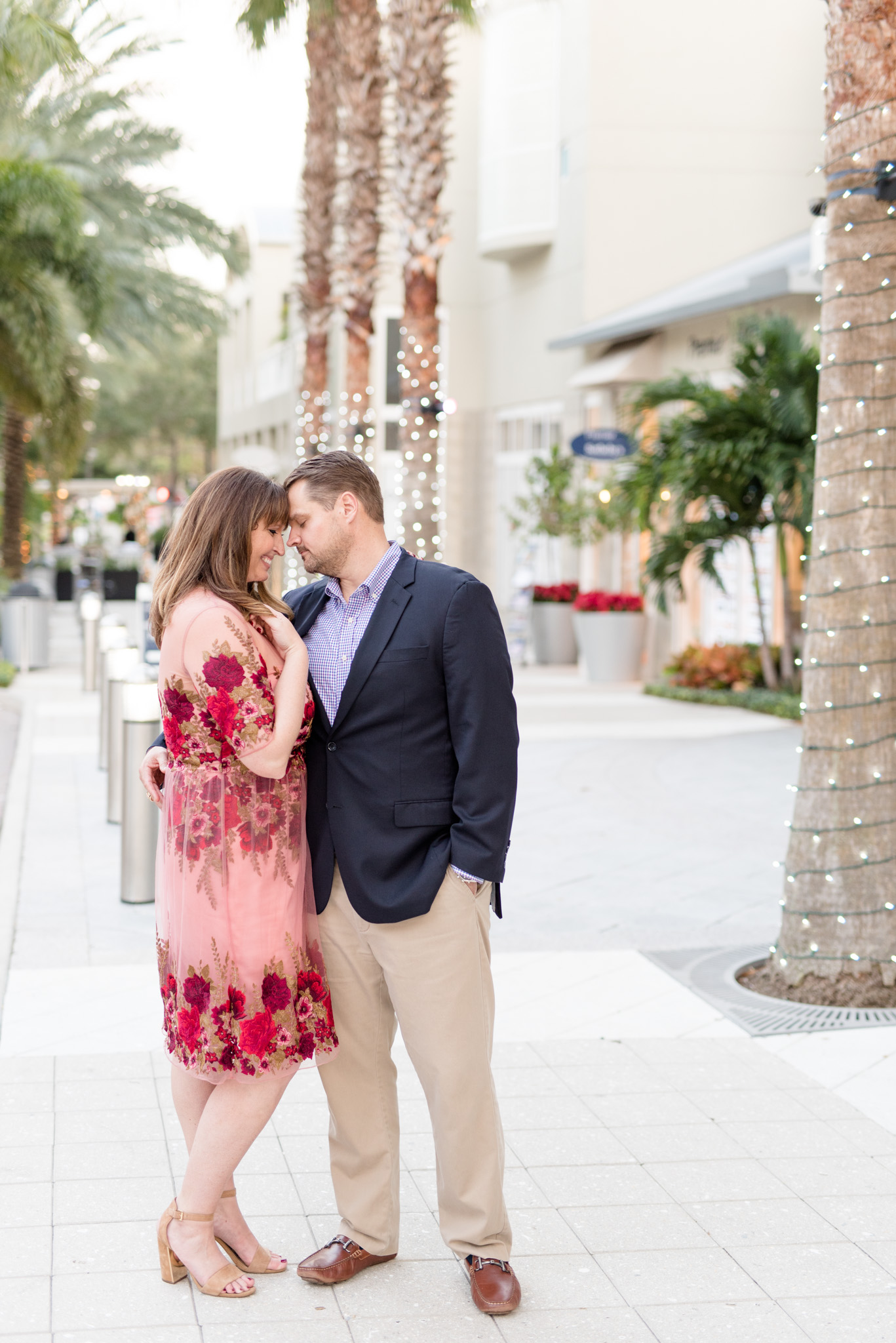 Engaged couple snuggles with urban backdrop.