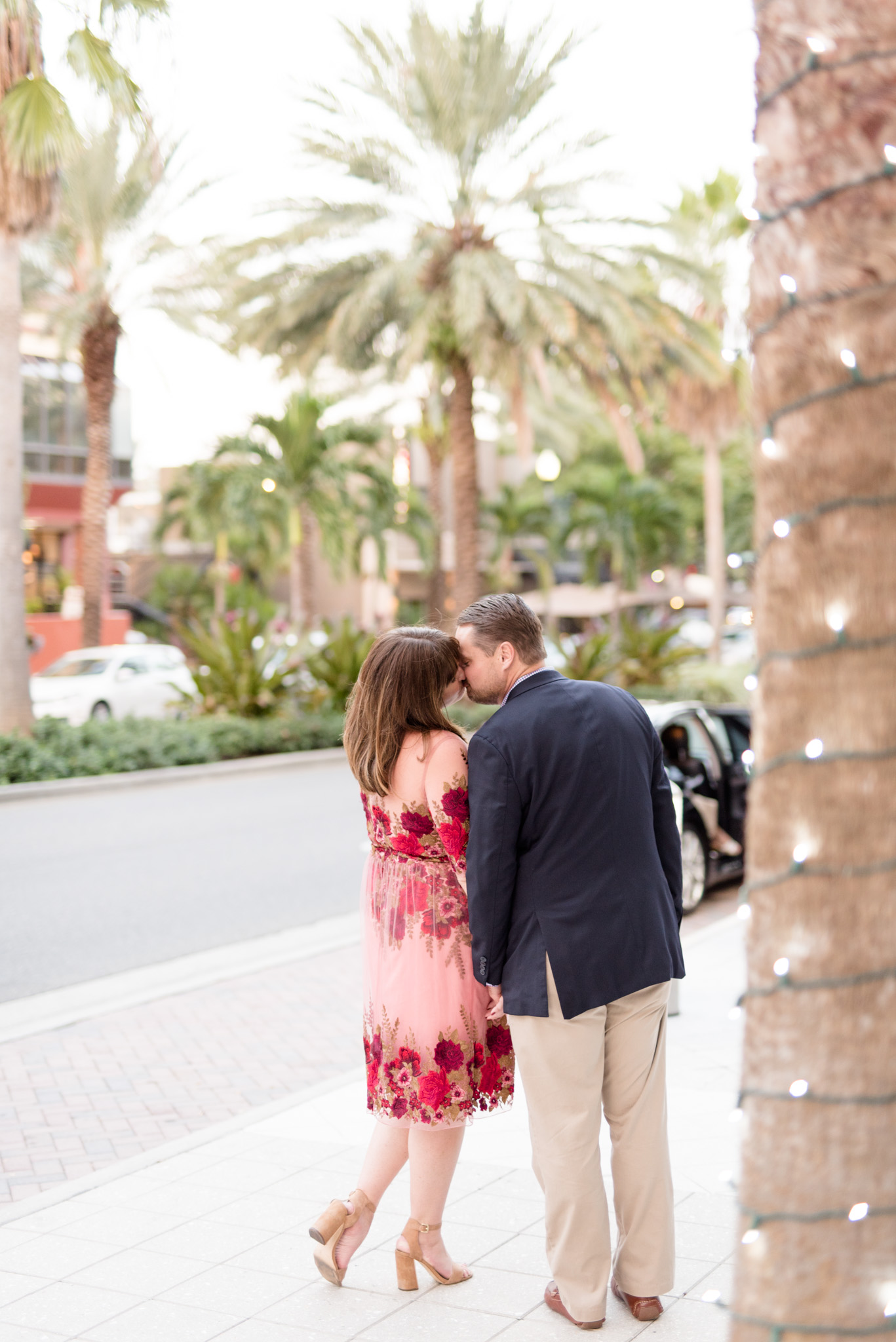 Engaged couple kisses in urban setting.