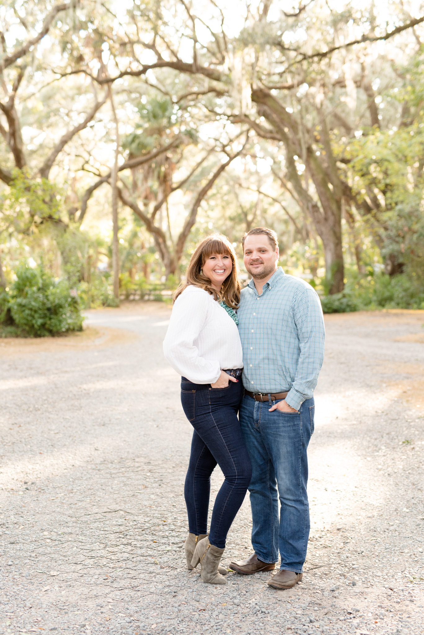 Couple smiles at camera in woodland.