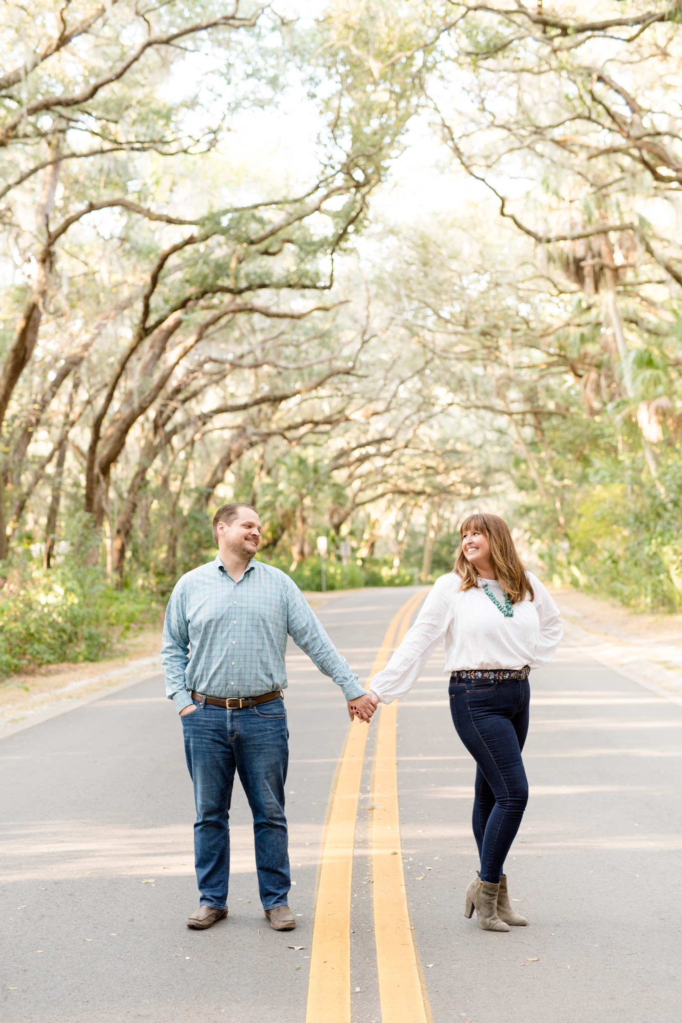 Couple smiles while standing in road.