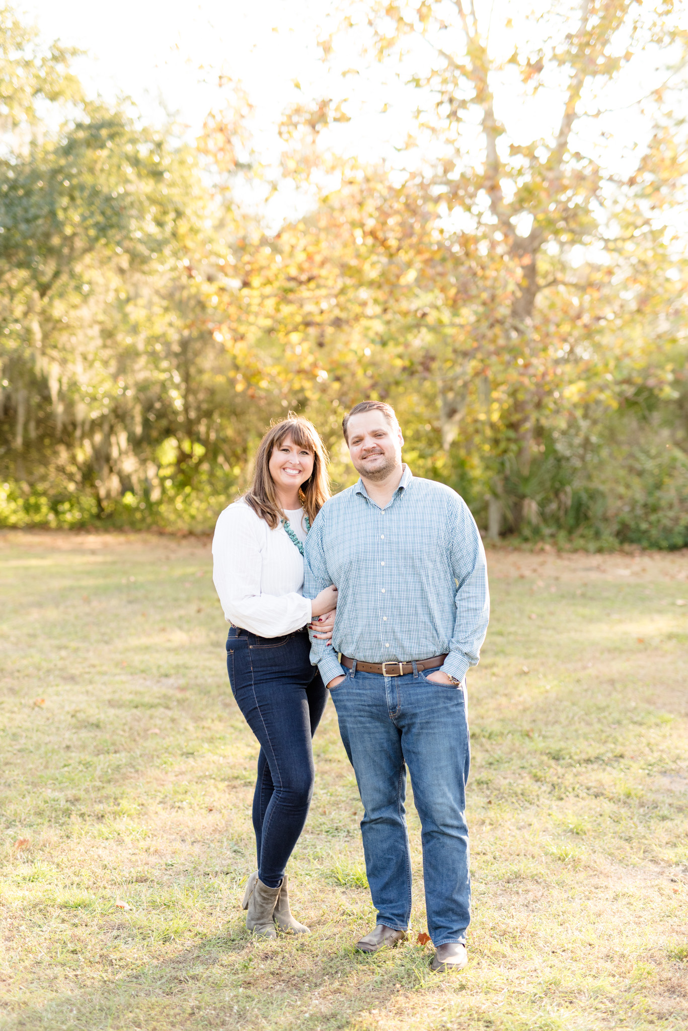 Couple smiles at camera at sunset.