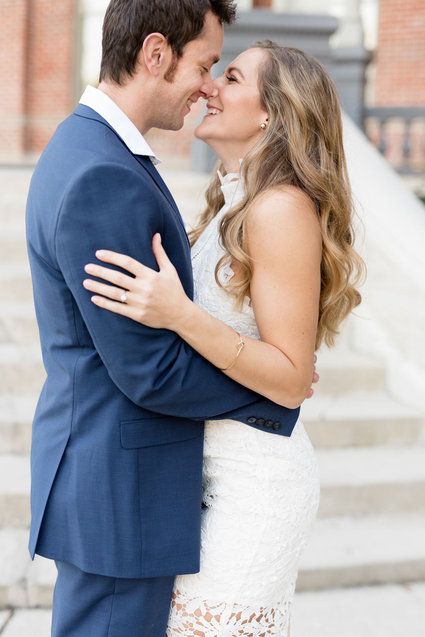 Engaged couple leans in for kiss.