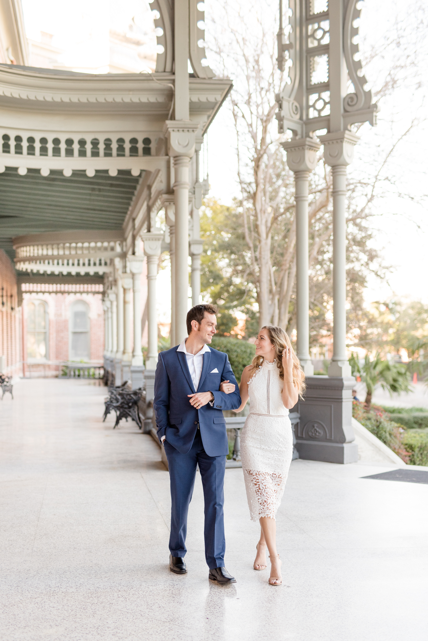 Couple walks along patio pathway.