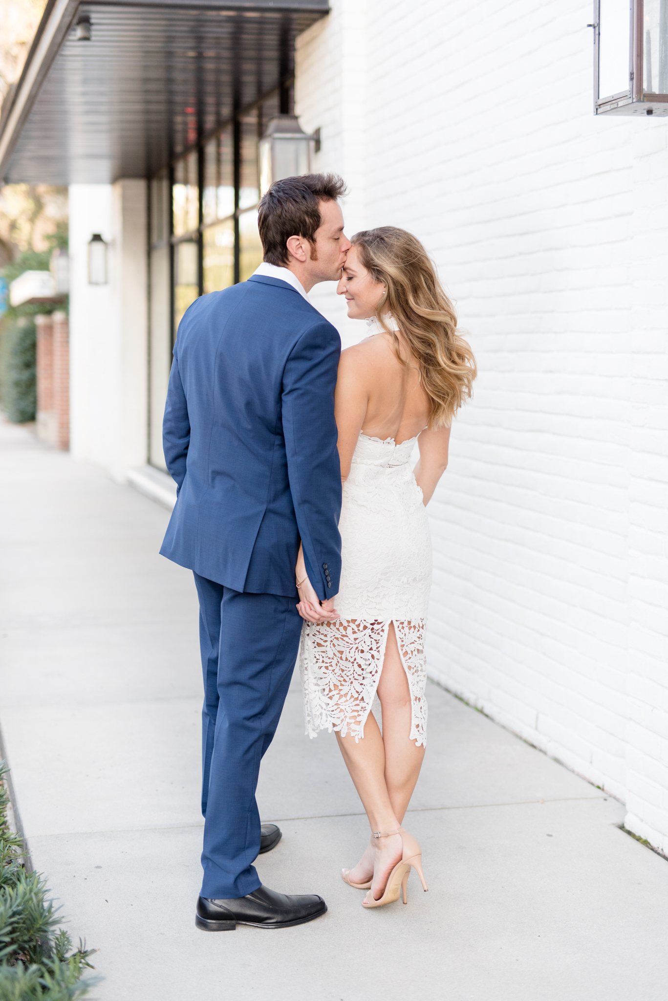 Guy kisses fiance on forehead.