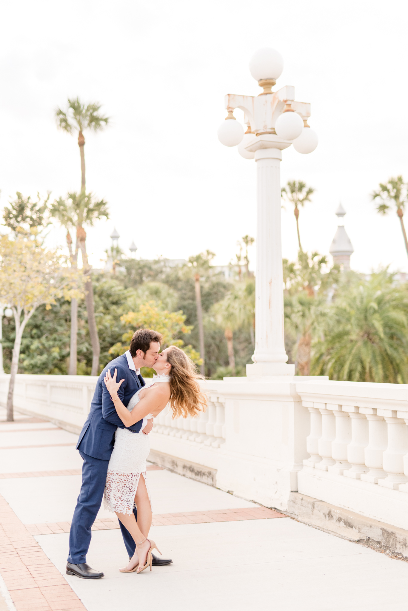 Man dips fiance on stone bridge.