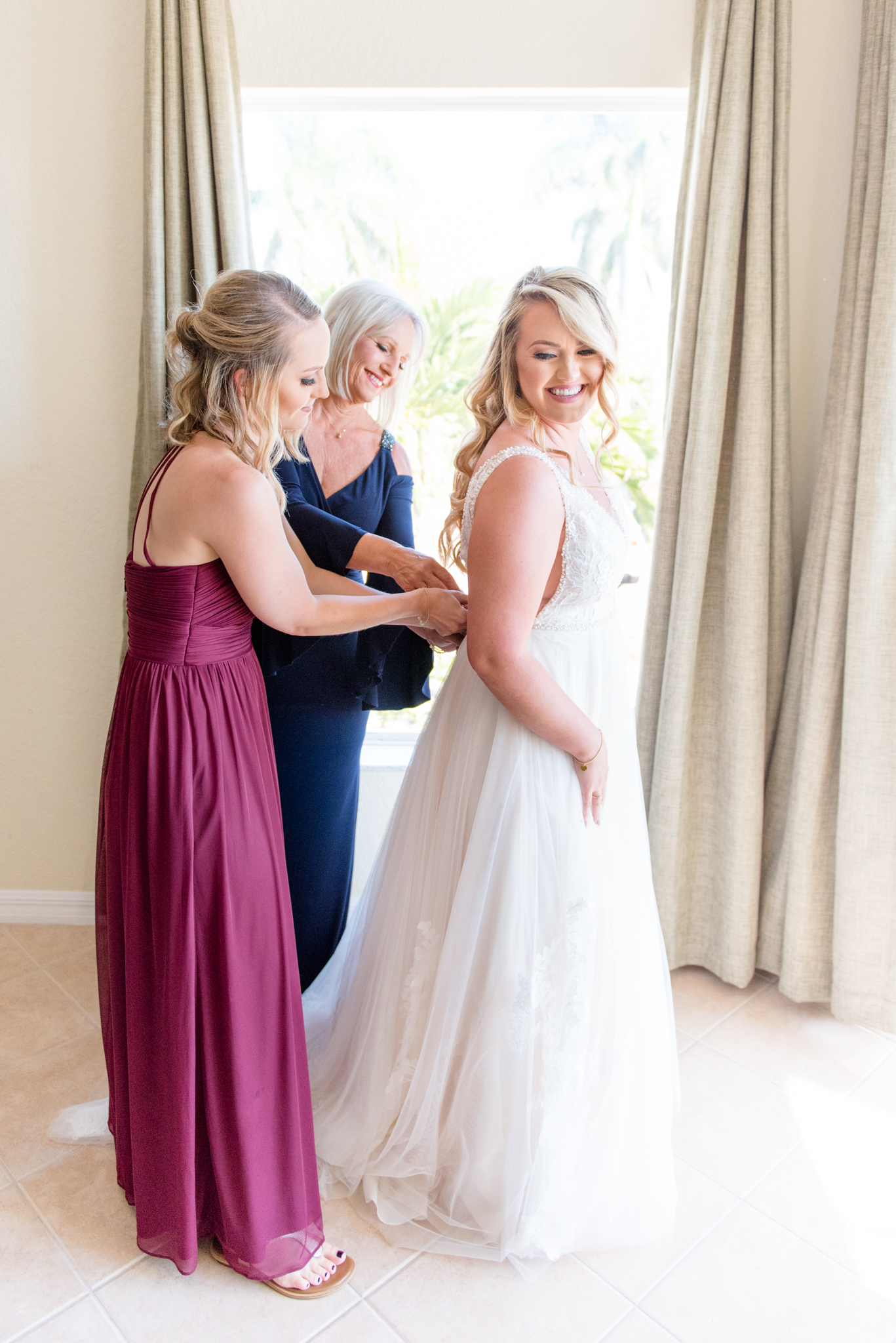 Bride's mother and sister help her get ready.