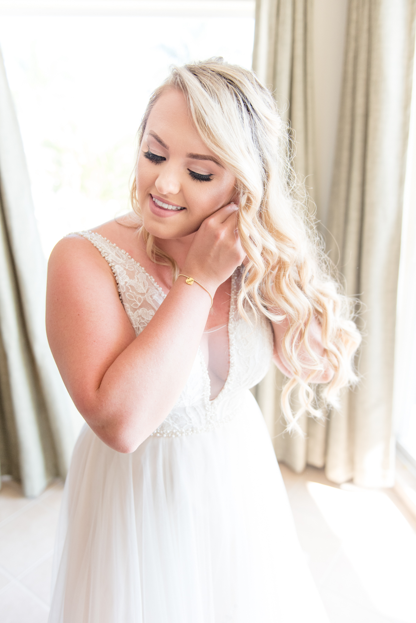 Bride puts on earrings.