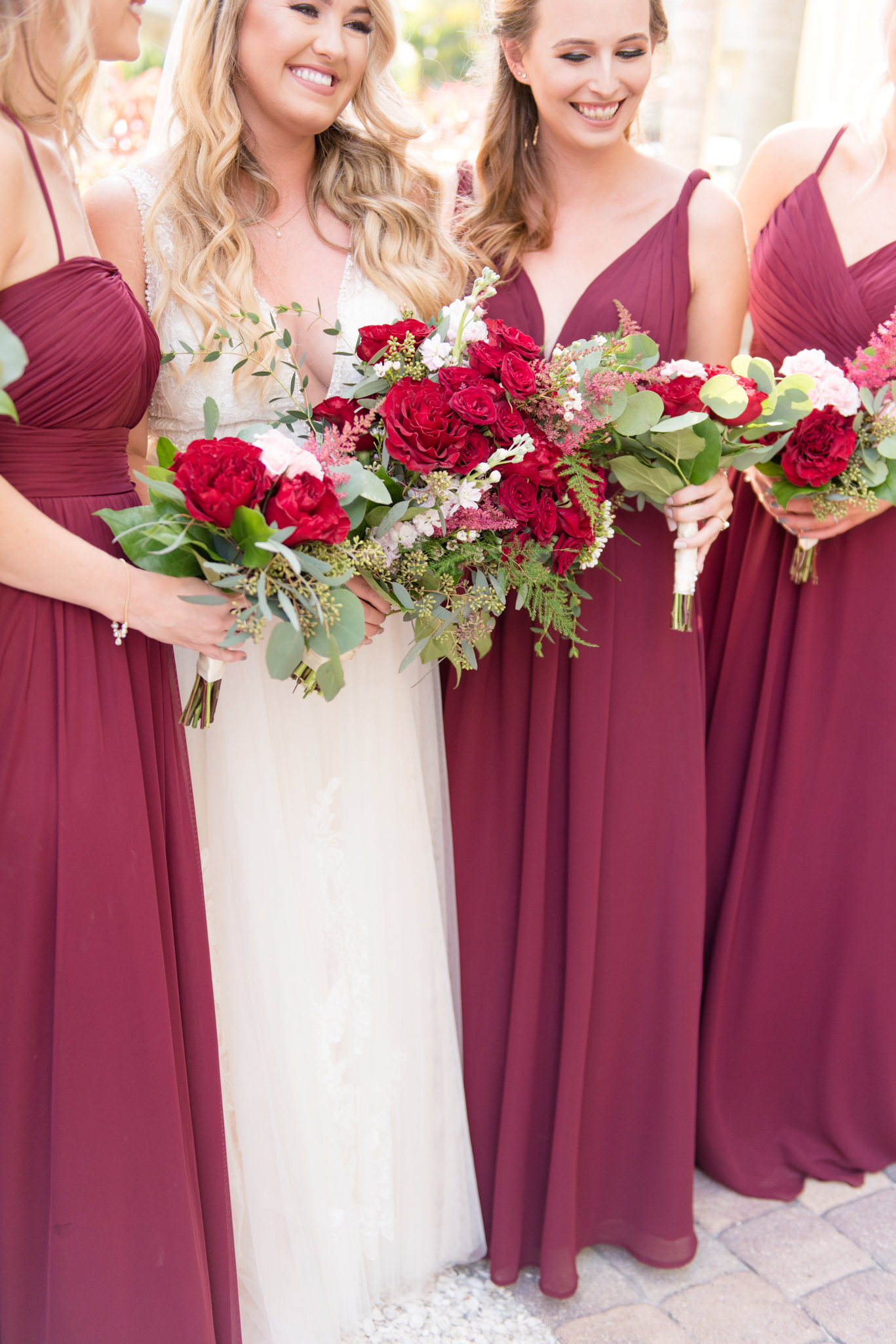 Bride and bridesmaids hold flowers.