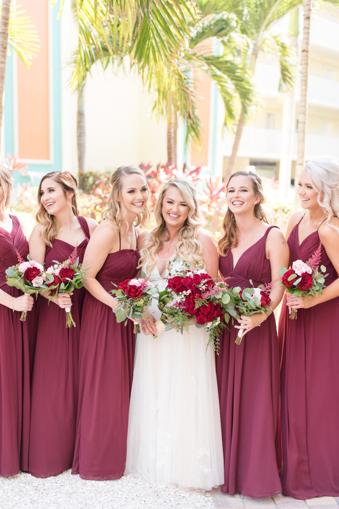 Bride and bridesmaids laugh together.