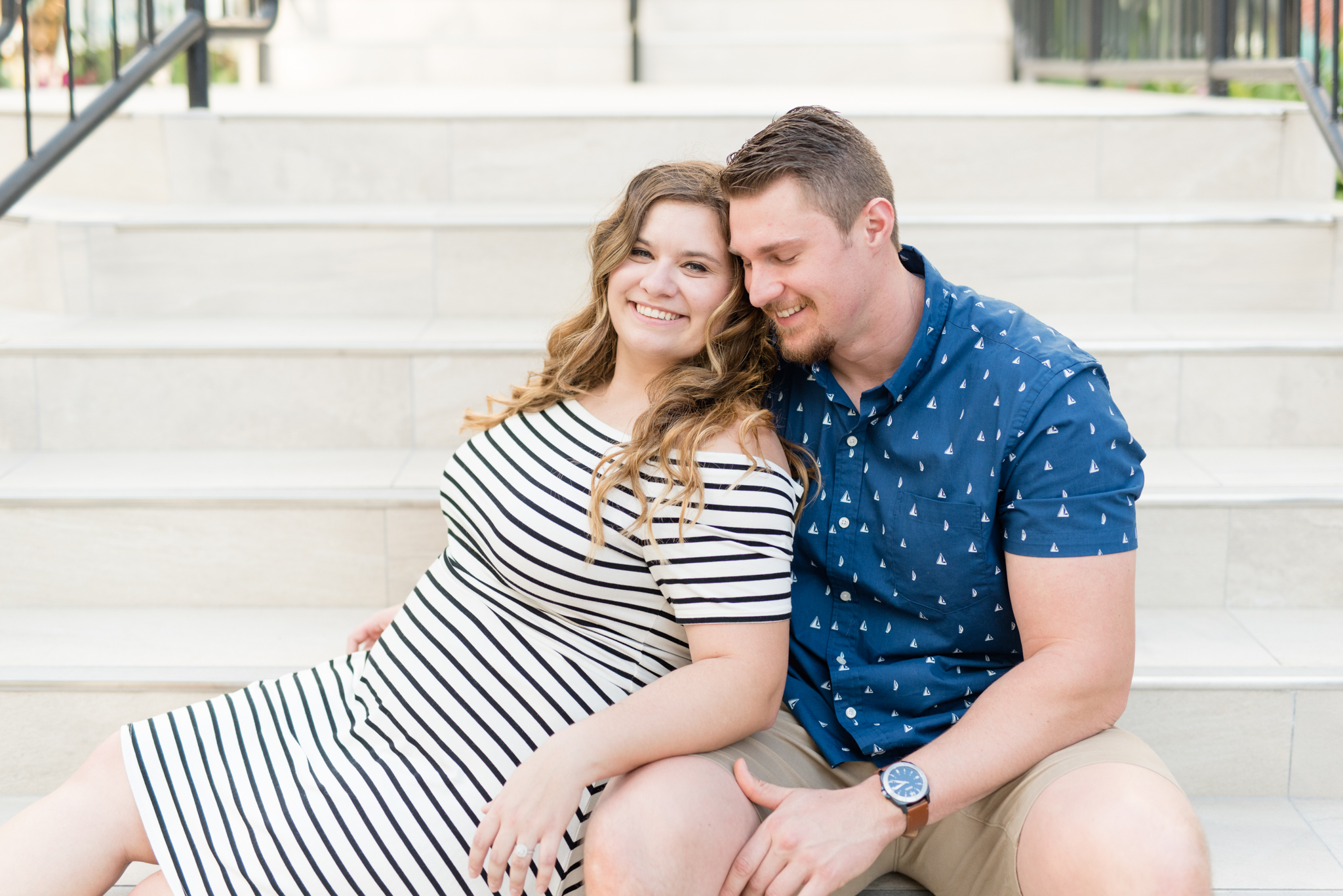 Couple sits on stone stairs.