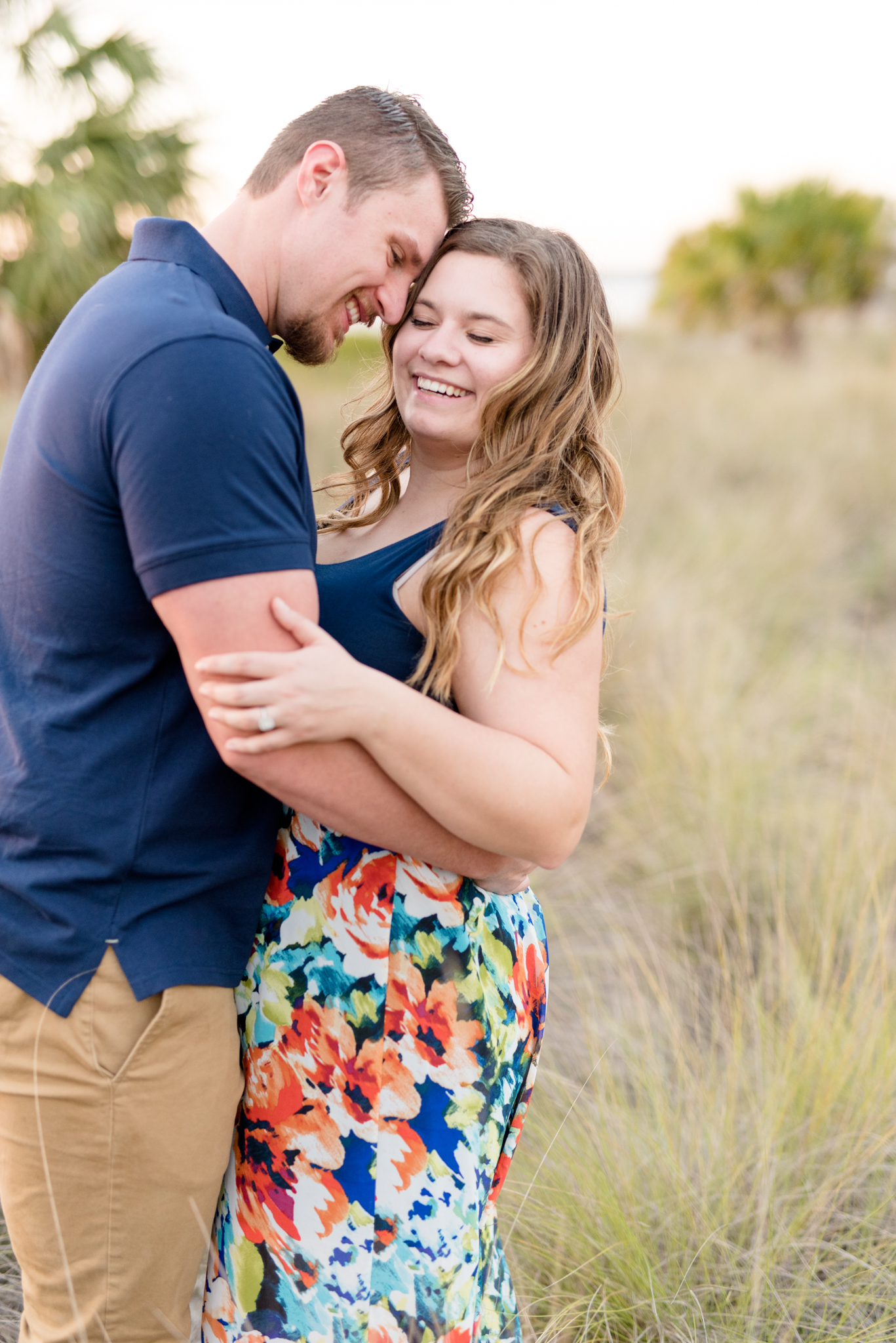 Couple laughs in beach grass.