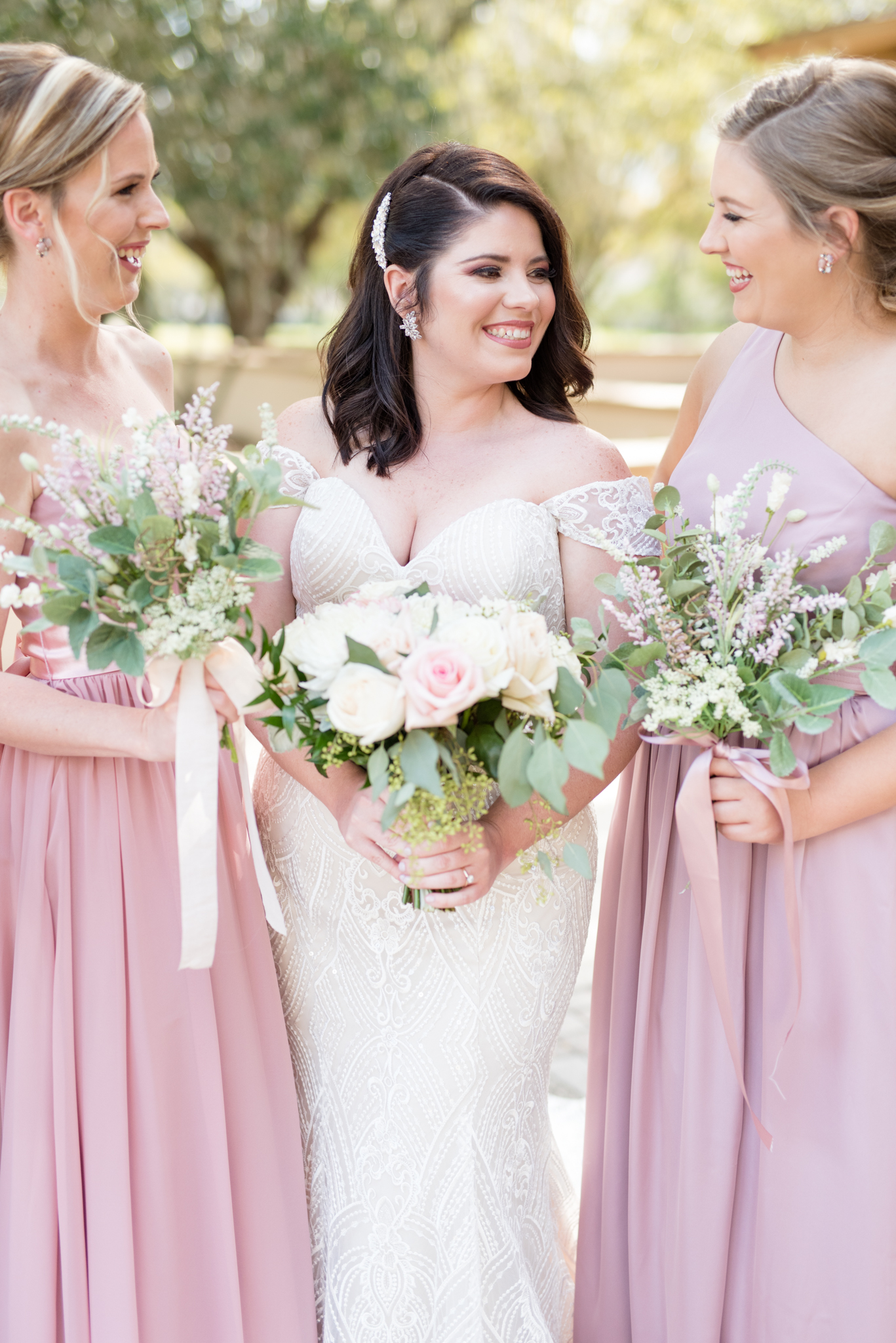 Bride and bridesmaids look at each other.