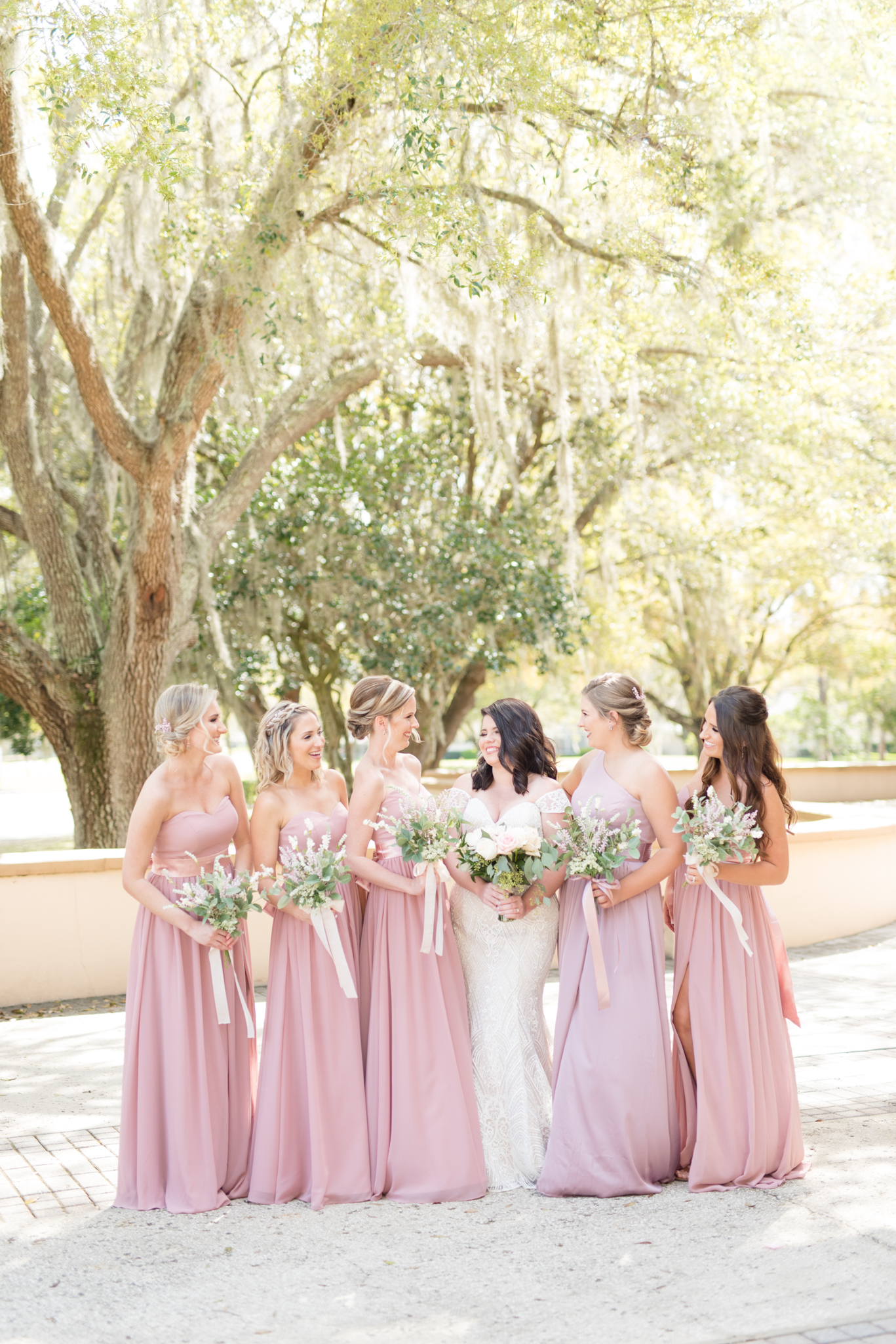 Bridal party laughs on balcony.