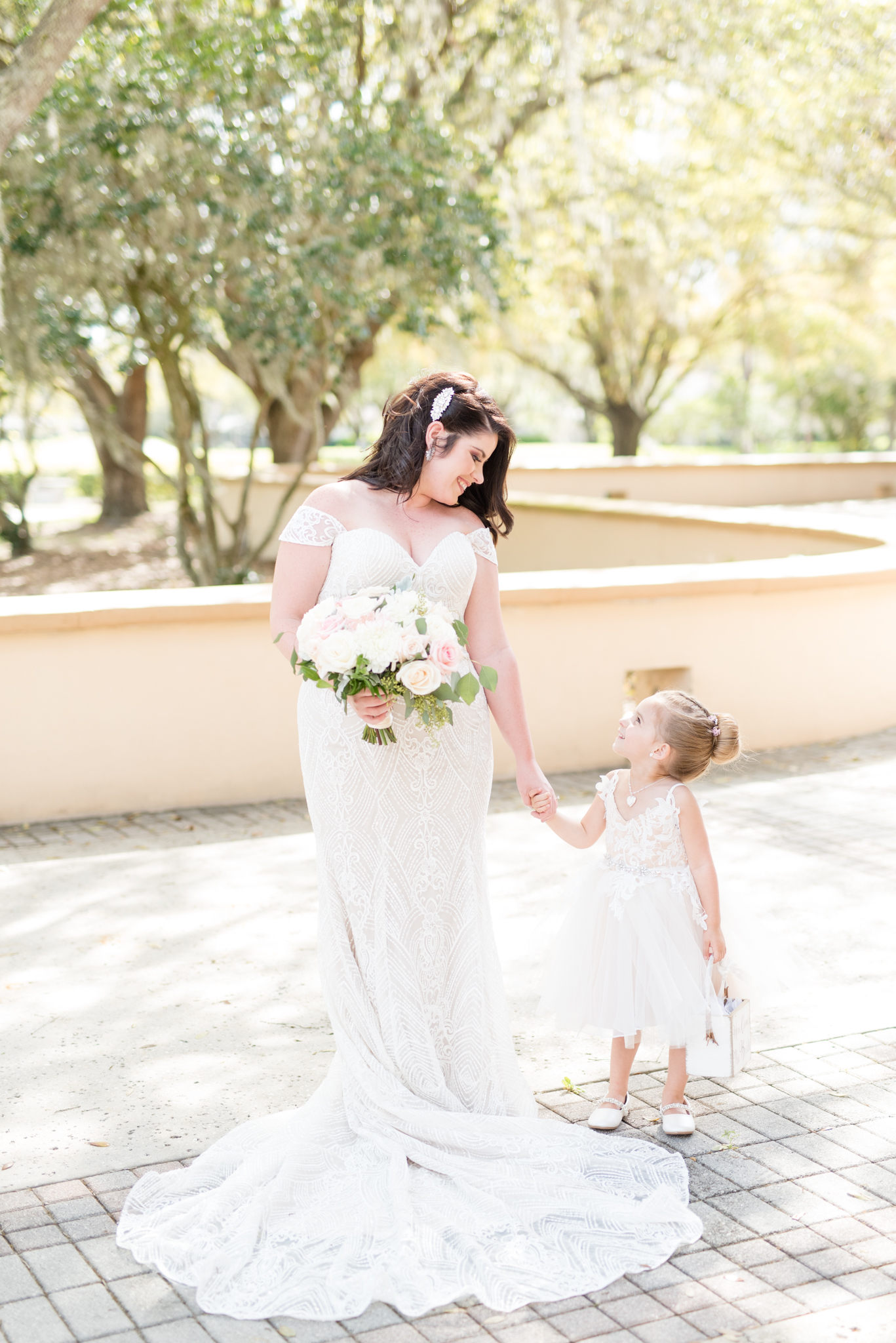 Flower girl looks up at bride.