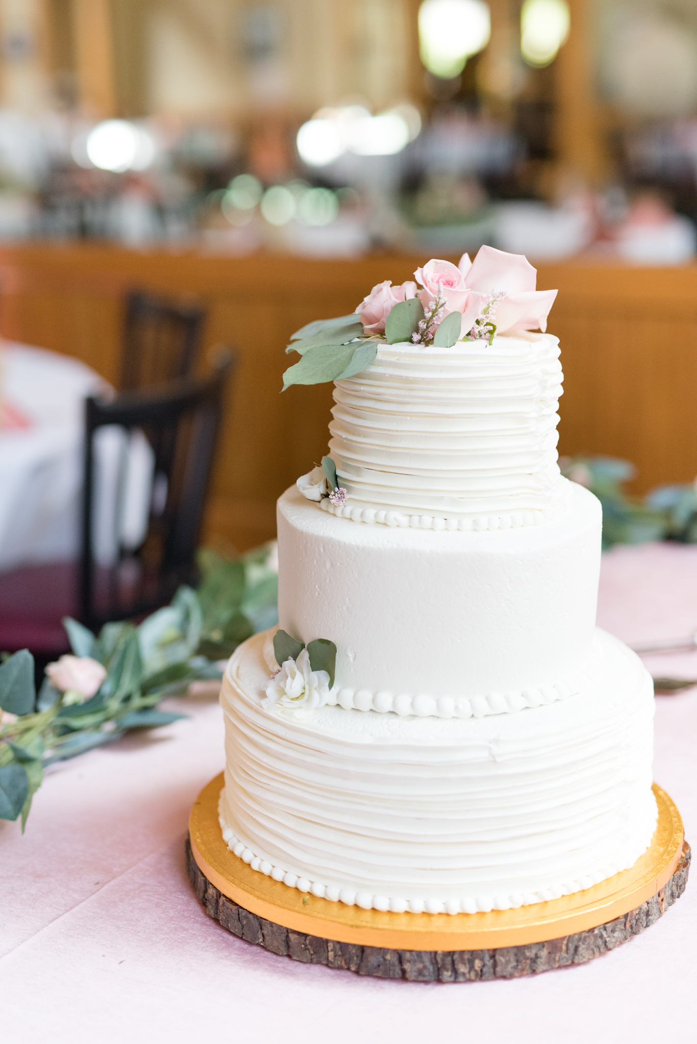 Wedding cake sits on table.