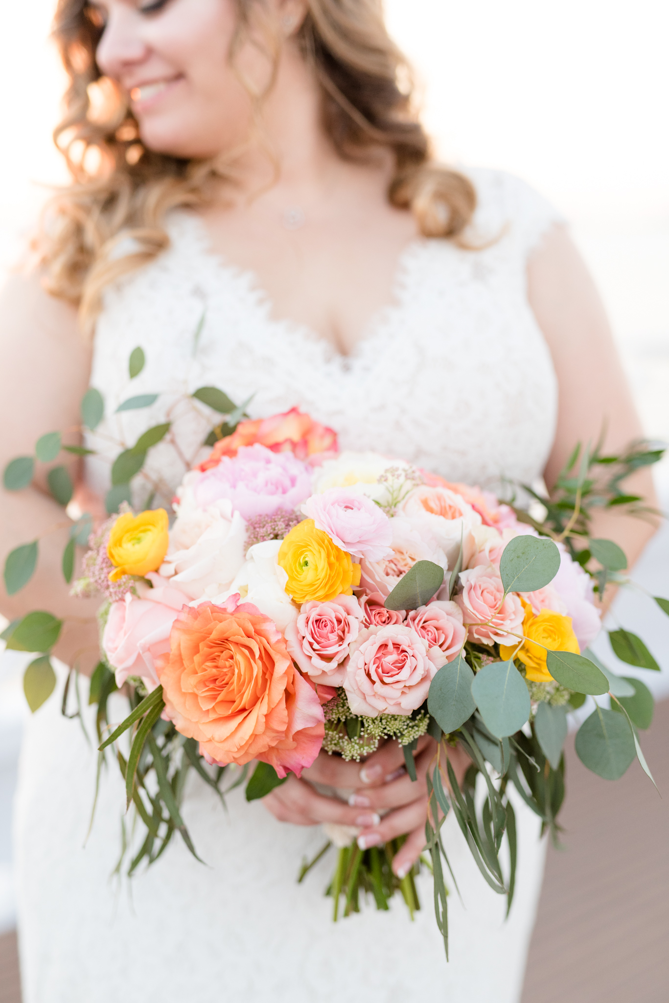 Bride holds wedding flowers on yacht.