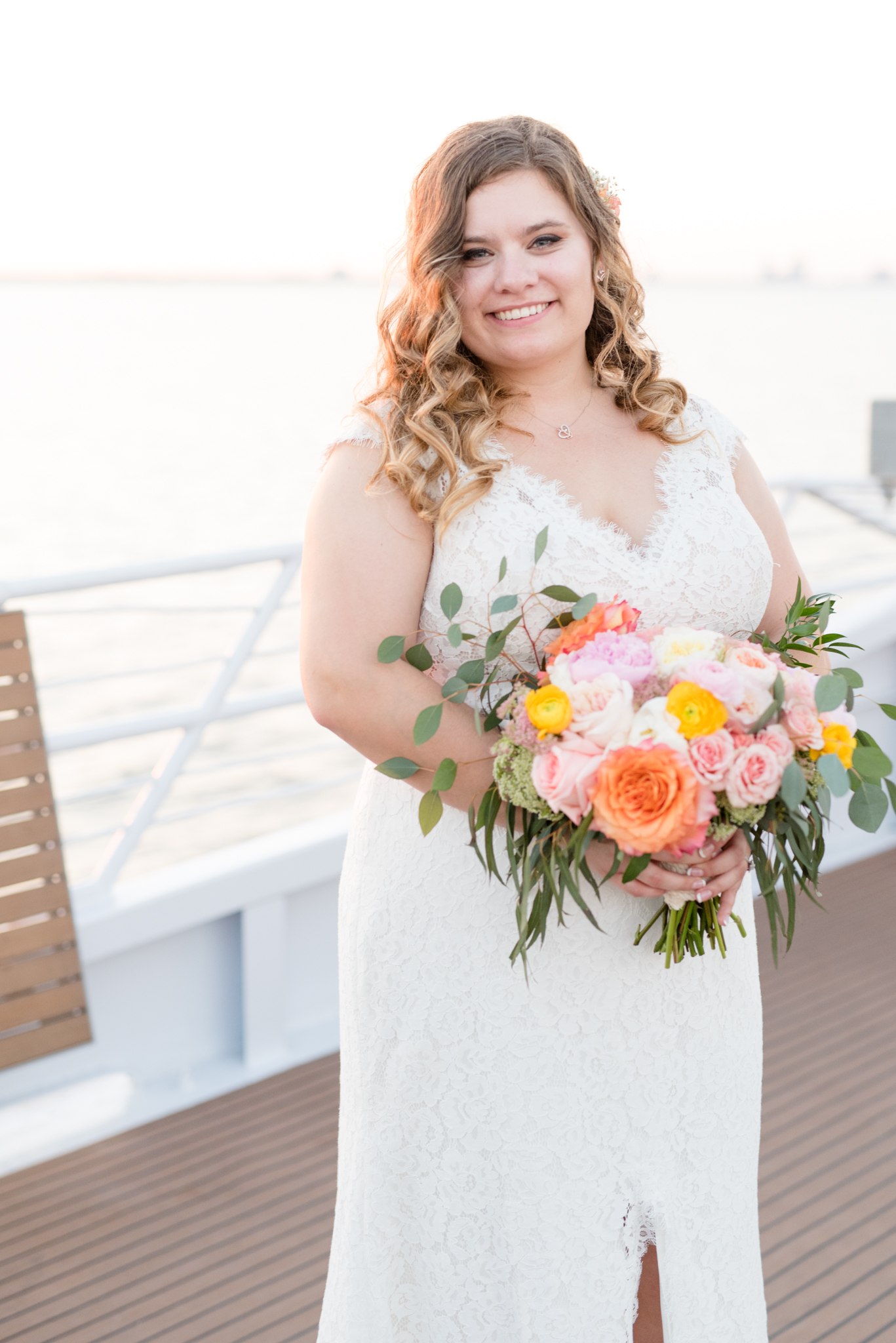 Bride smiles at camera on yacht.