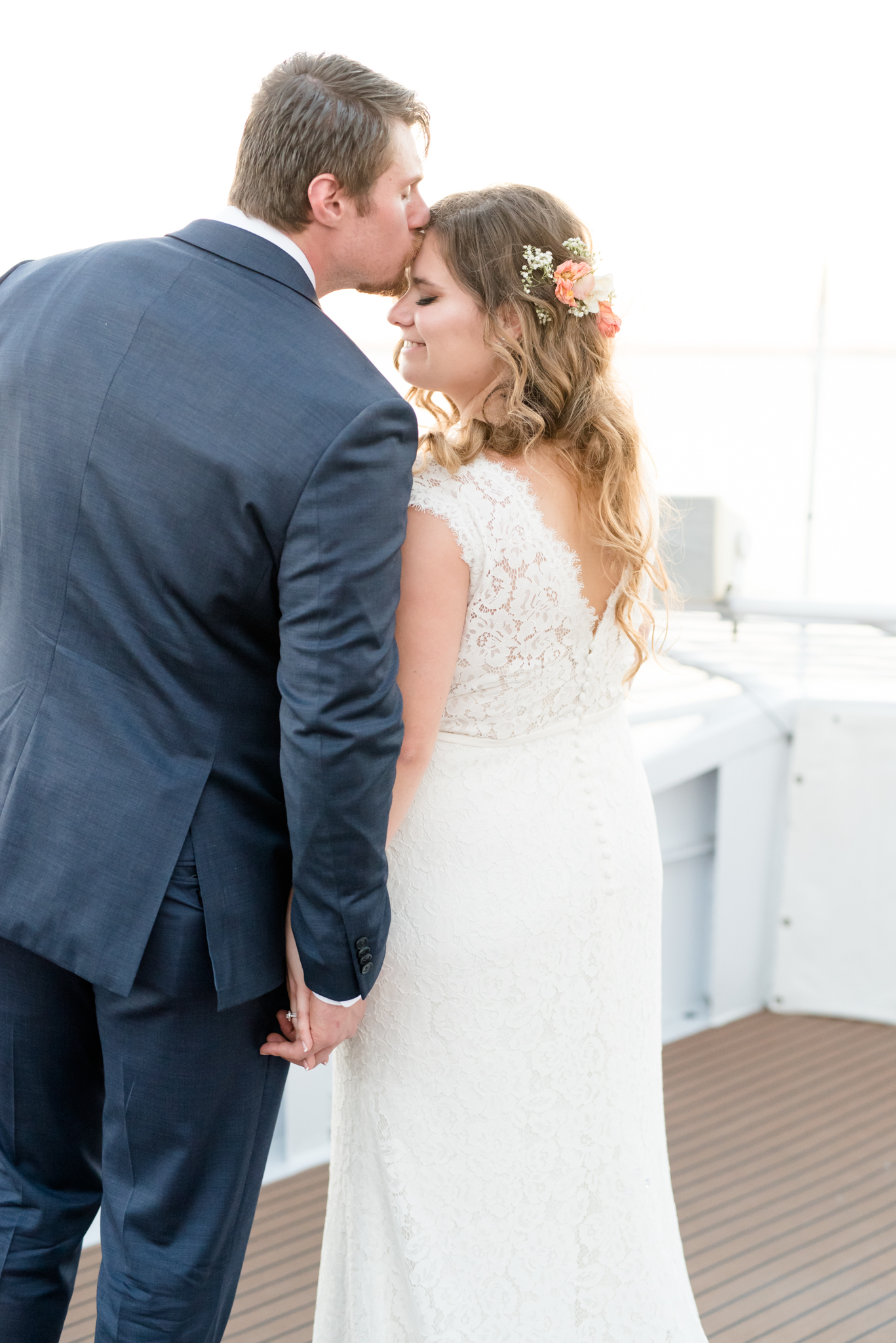 Groom kisses bride's forehead.