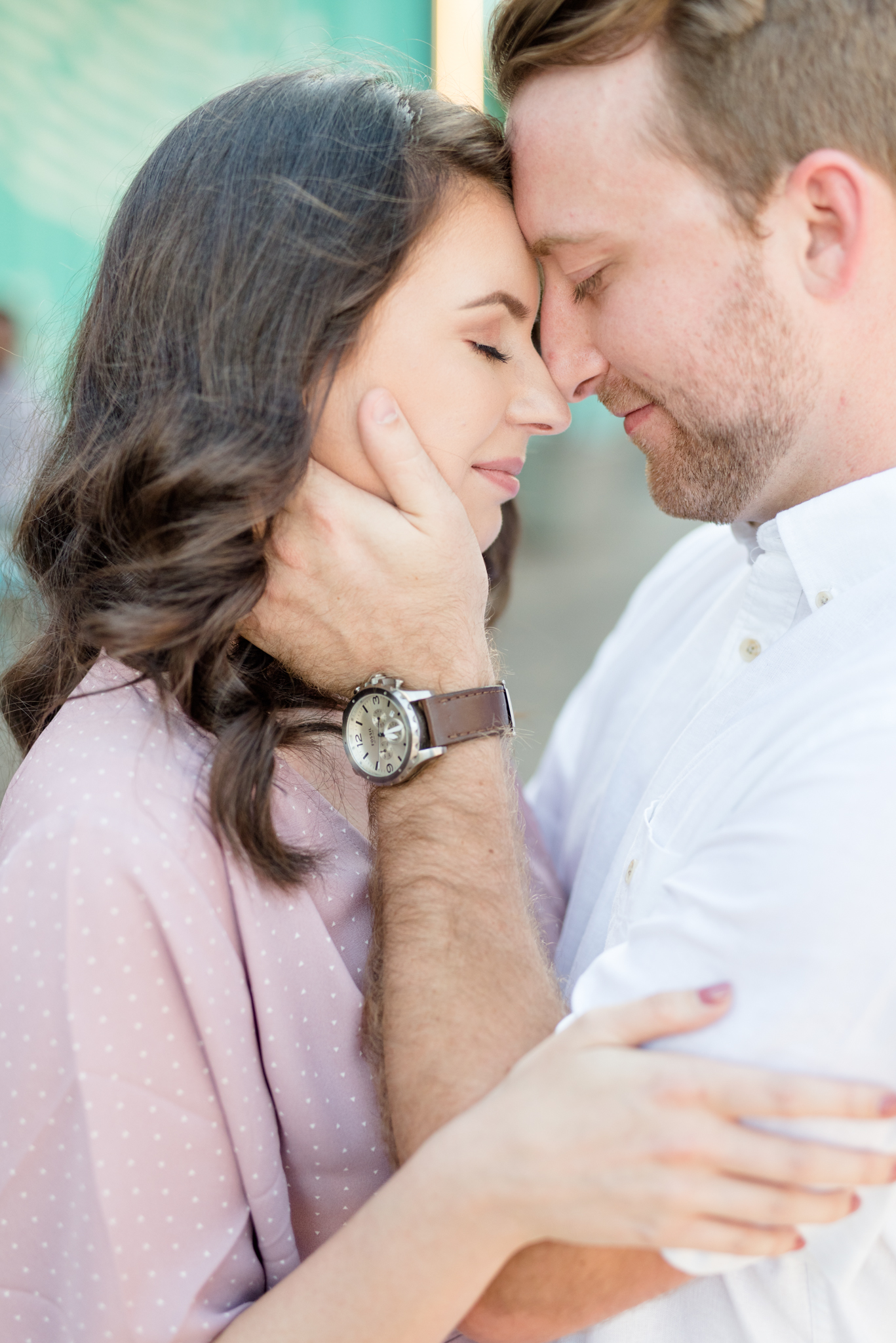 Couple snuggles closely together.