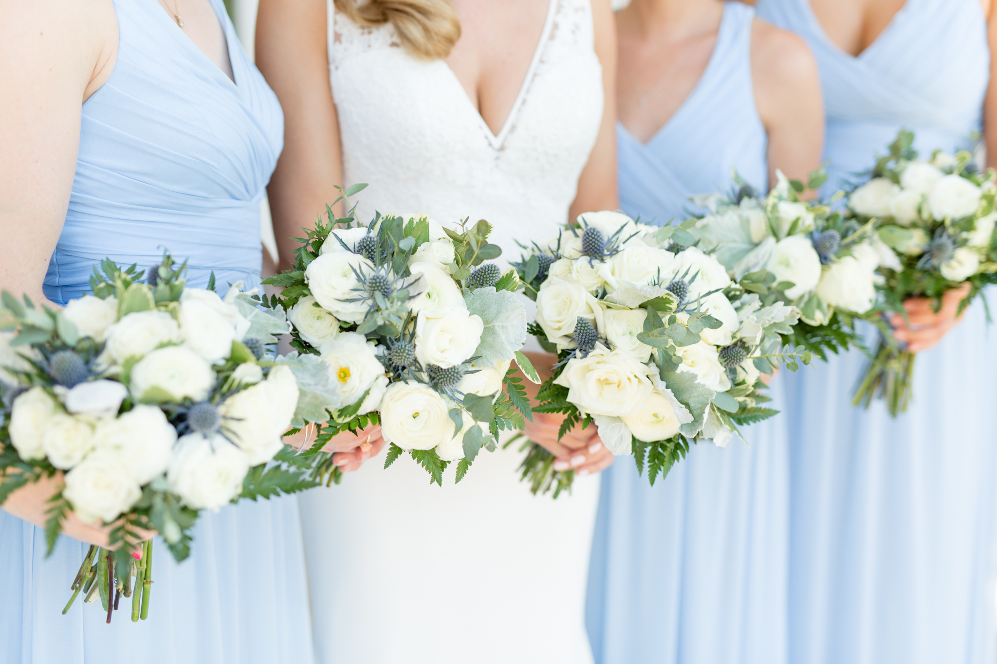 Bride and bridesmaids hold flowers.